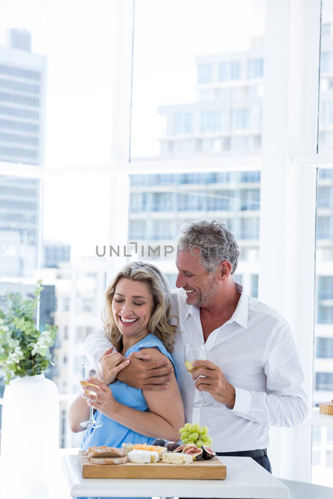 Romantic mature couple embracing while standing at restaurant