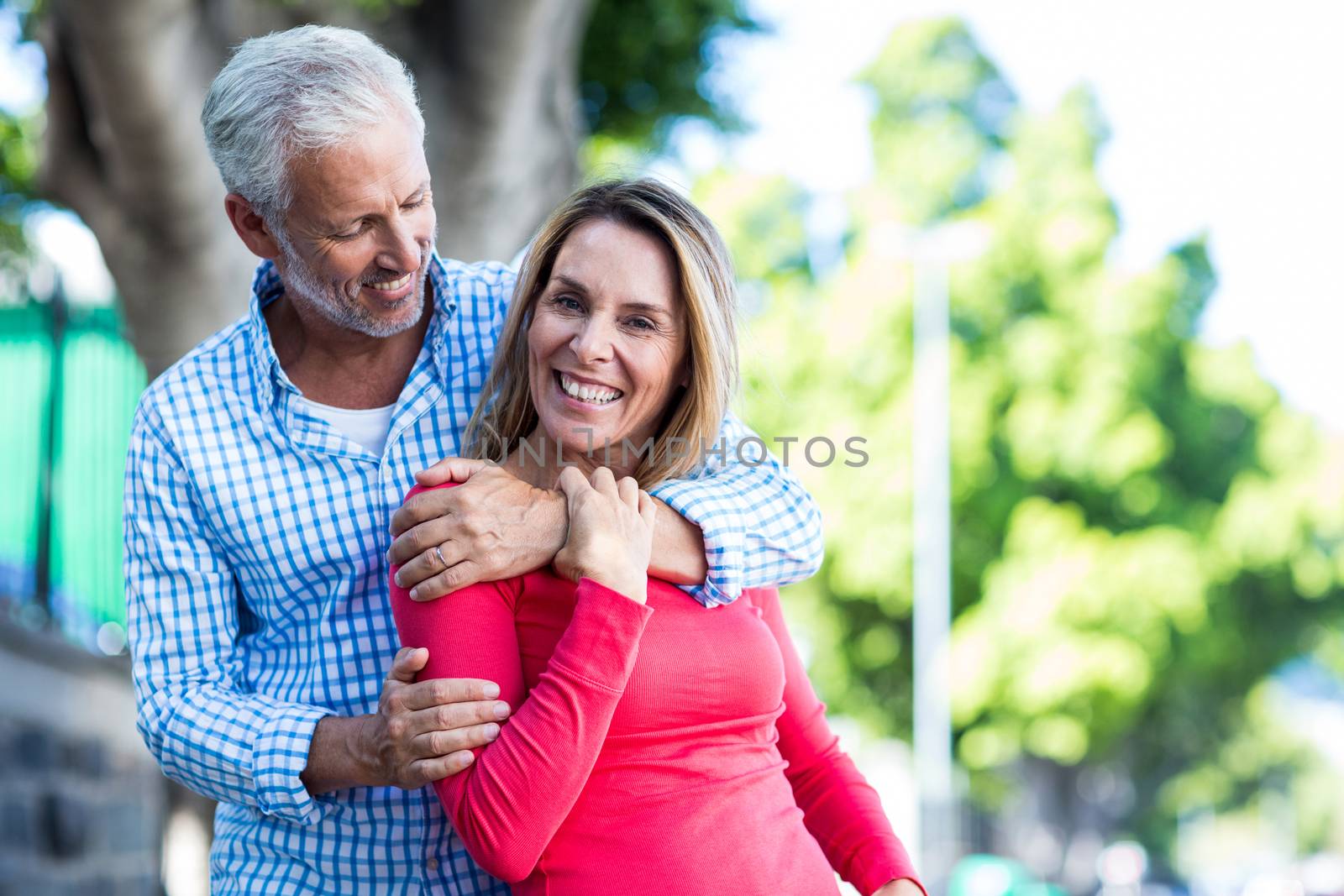 Romantic mature couple standing against tree in city