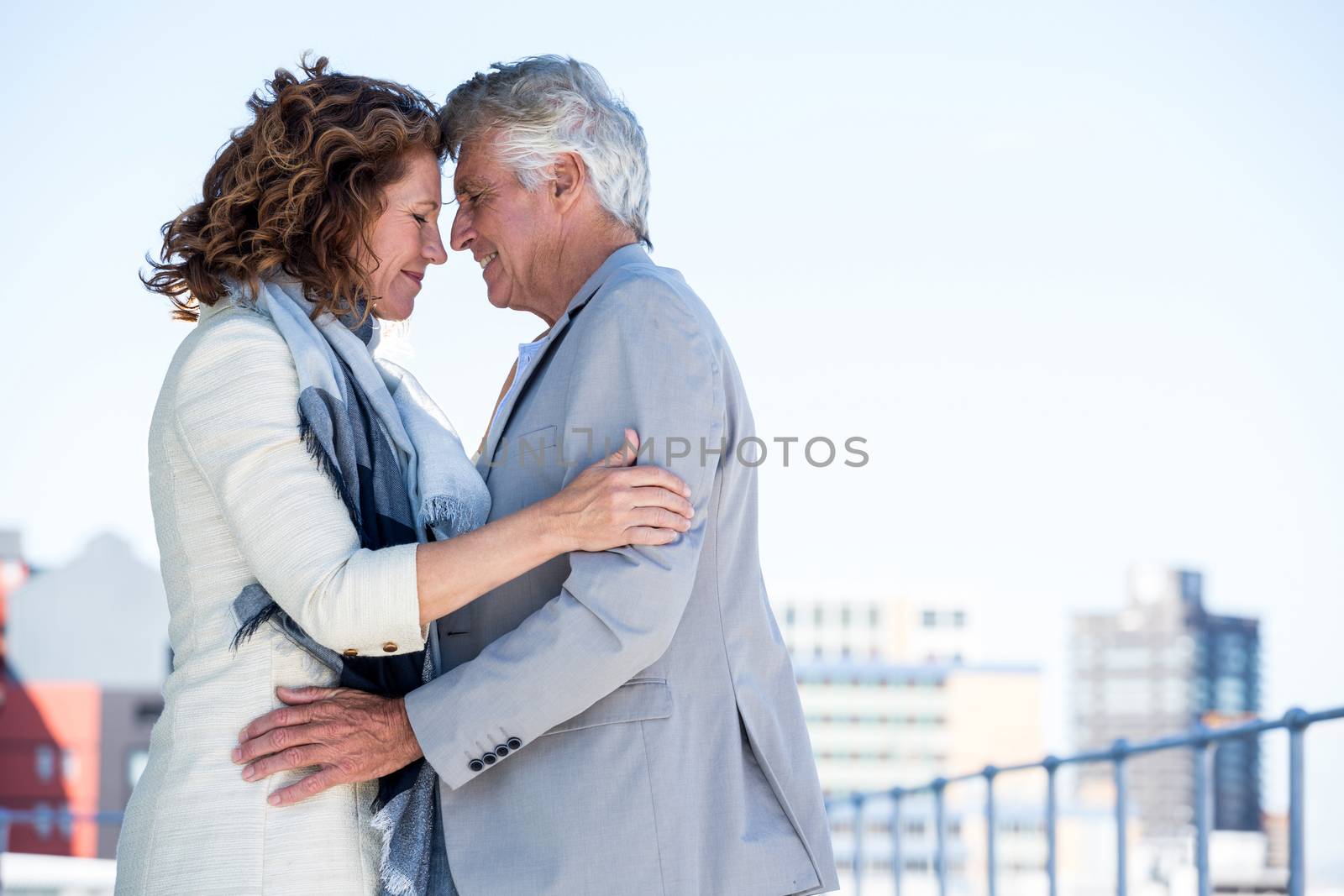 Side view of romantic mature couple standing against clear sky