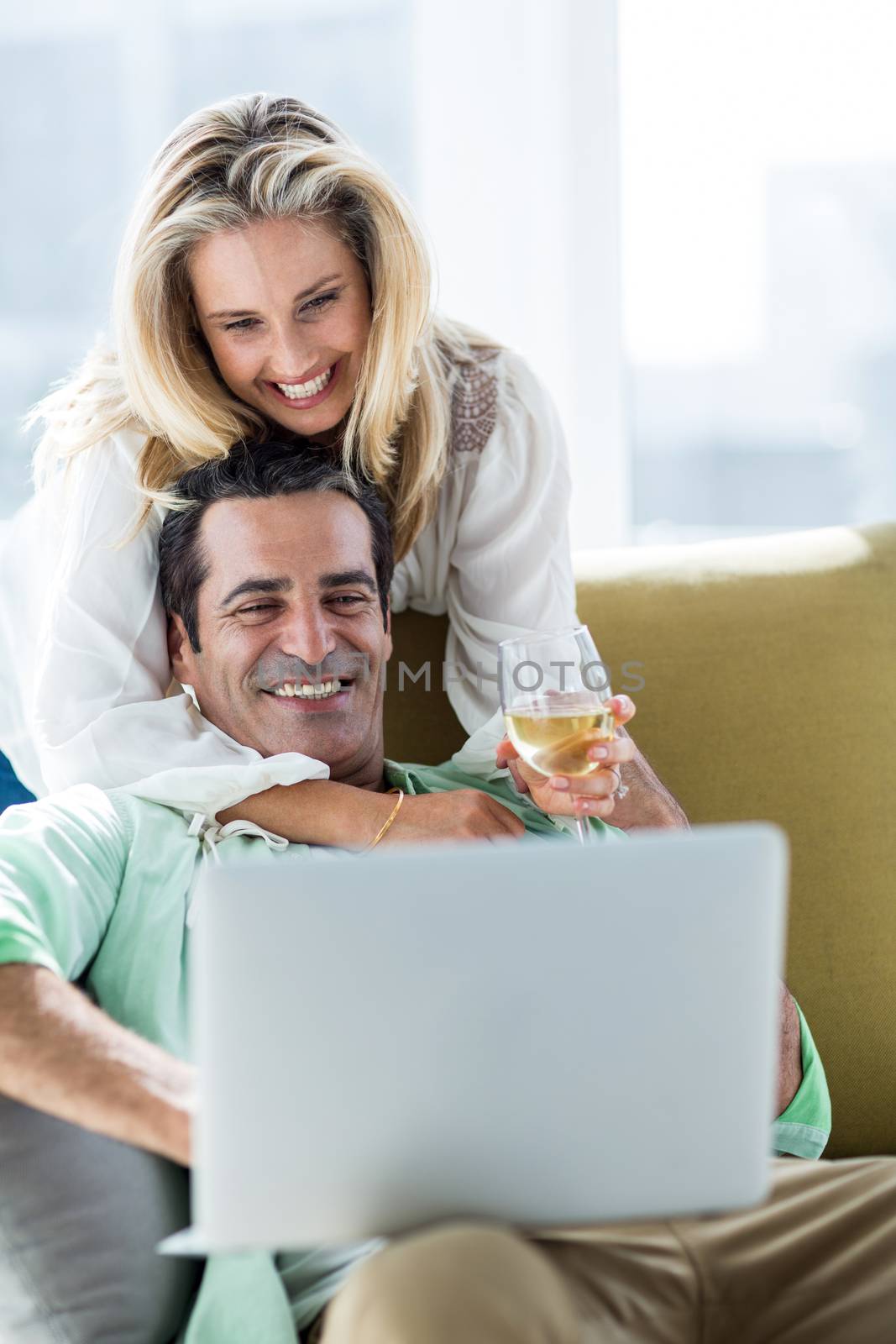 Romantic couple using laptop at home by Wavebreakmedia
