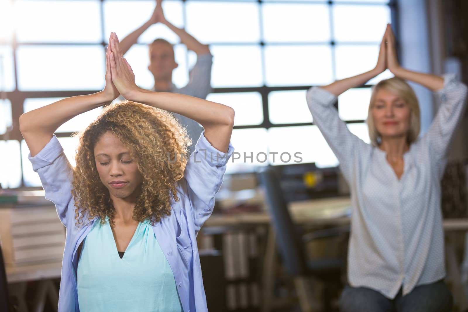 Creative business people practicing yoga  by Wavebreakmedia