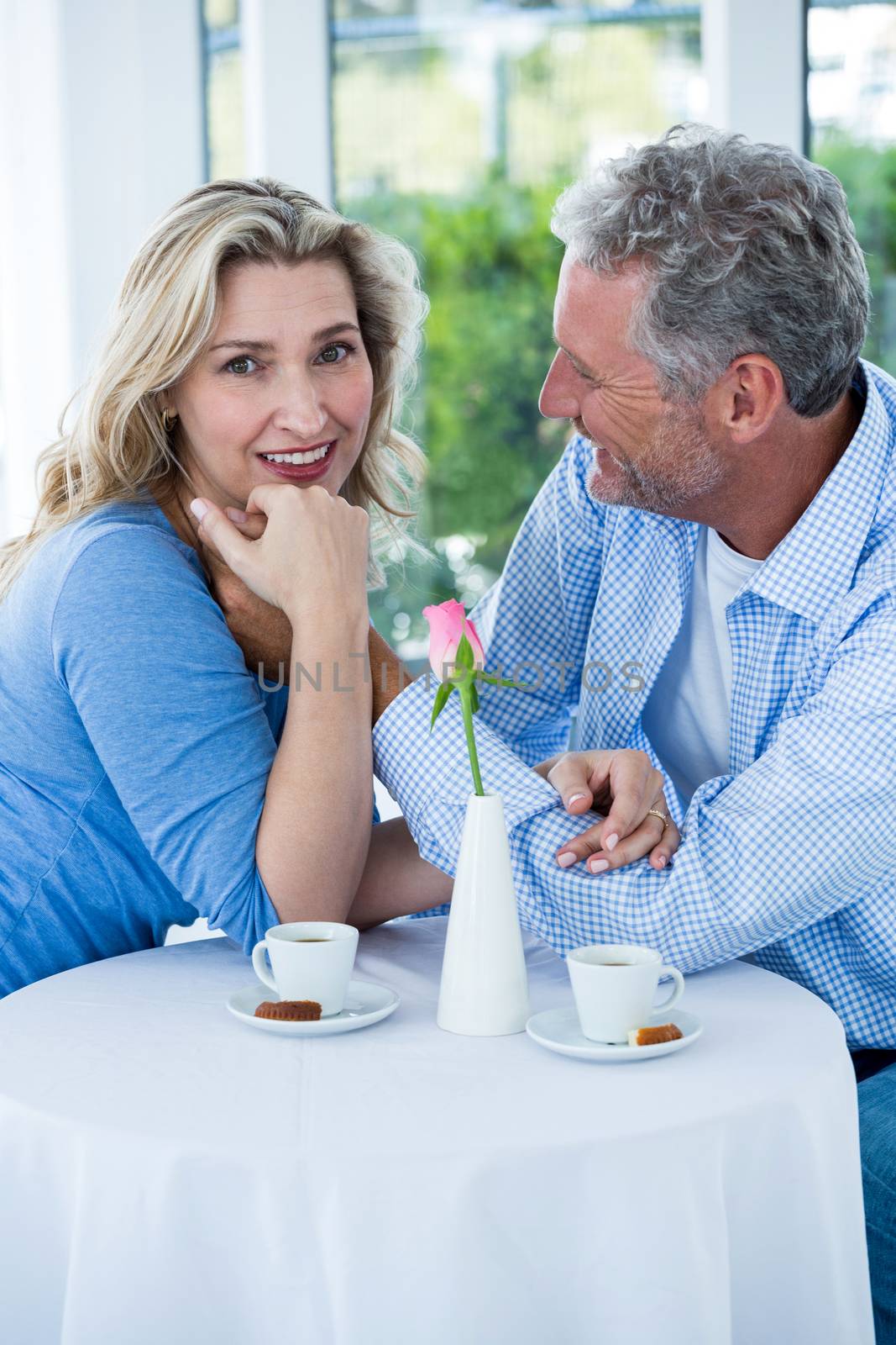 Happy romantic couple sitting at table in restaurant
