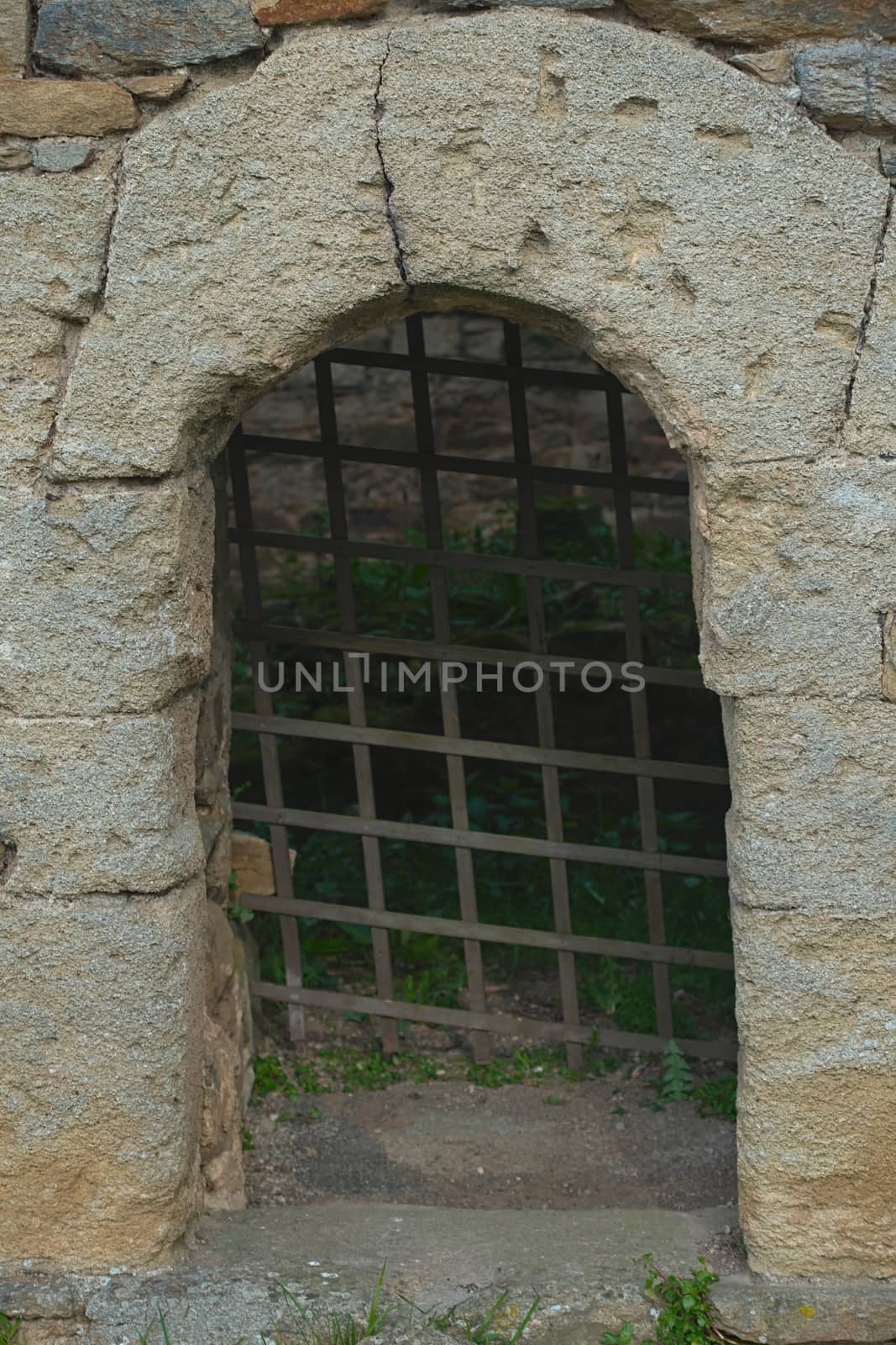 Stone archway and rustic metal gate representing dungeon entrance by sheriffkule
