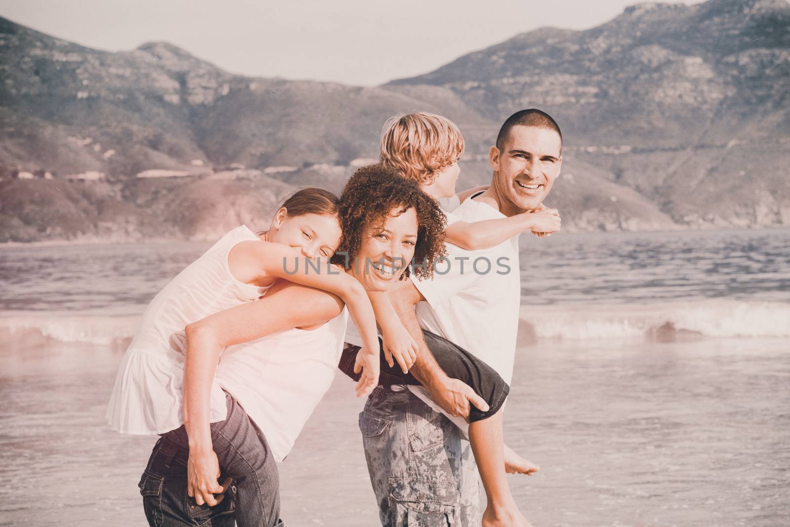 Happy family playing on the beach by Wavebreakmedia