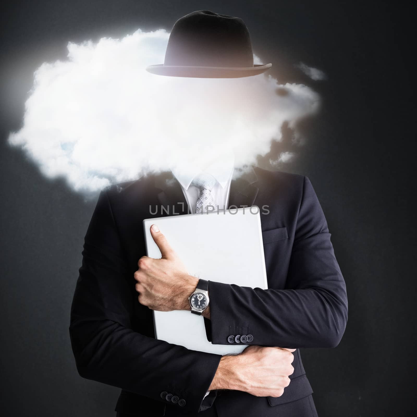 Mid section of businessman holding computer  against grey background