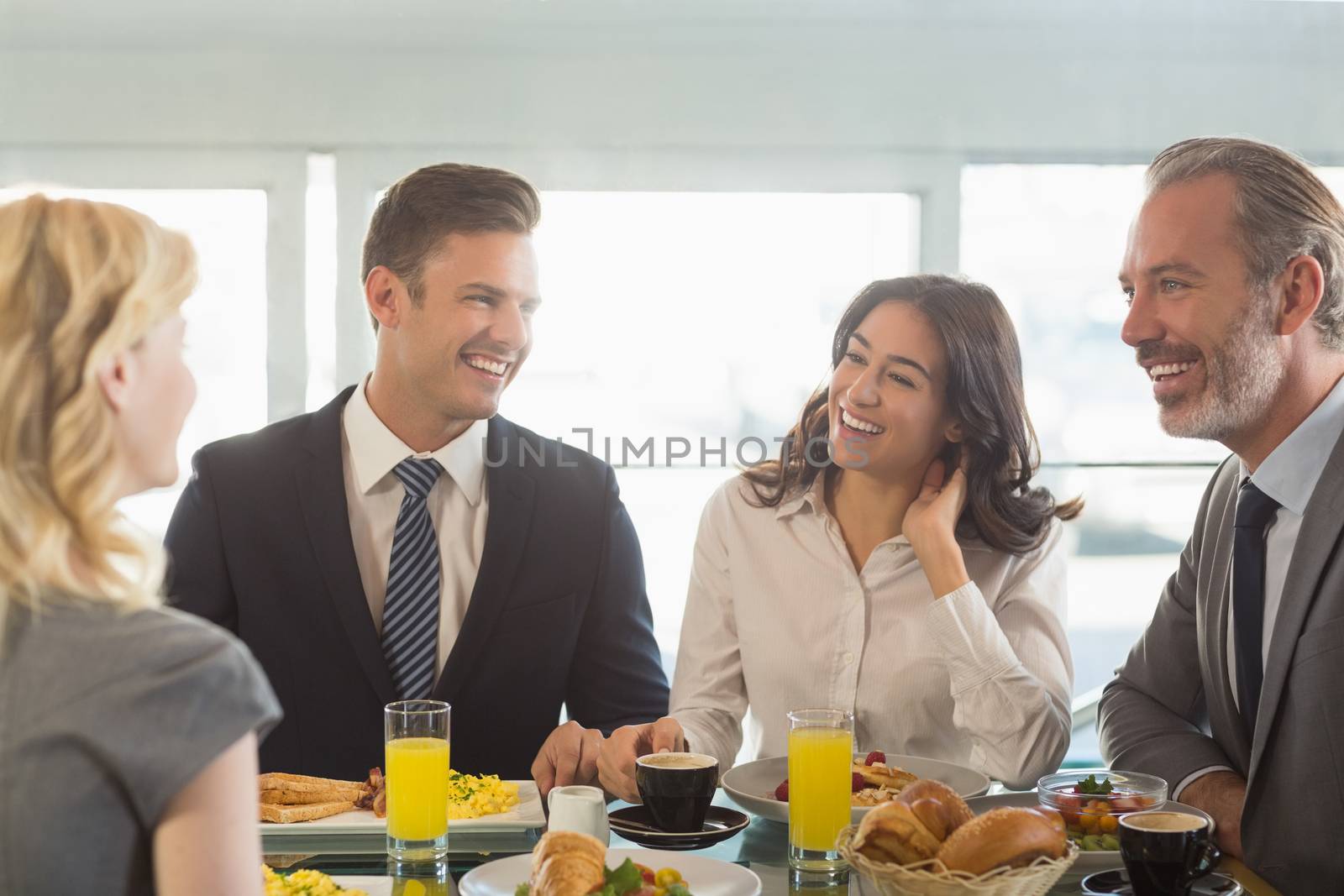 Business people interacting with eachother while having meal in restaurant