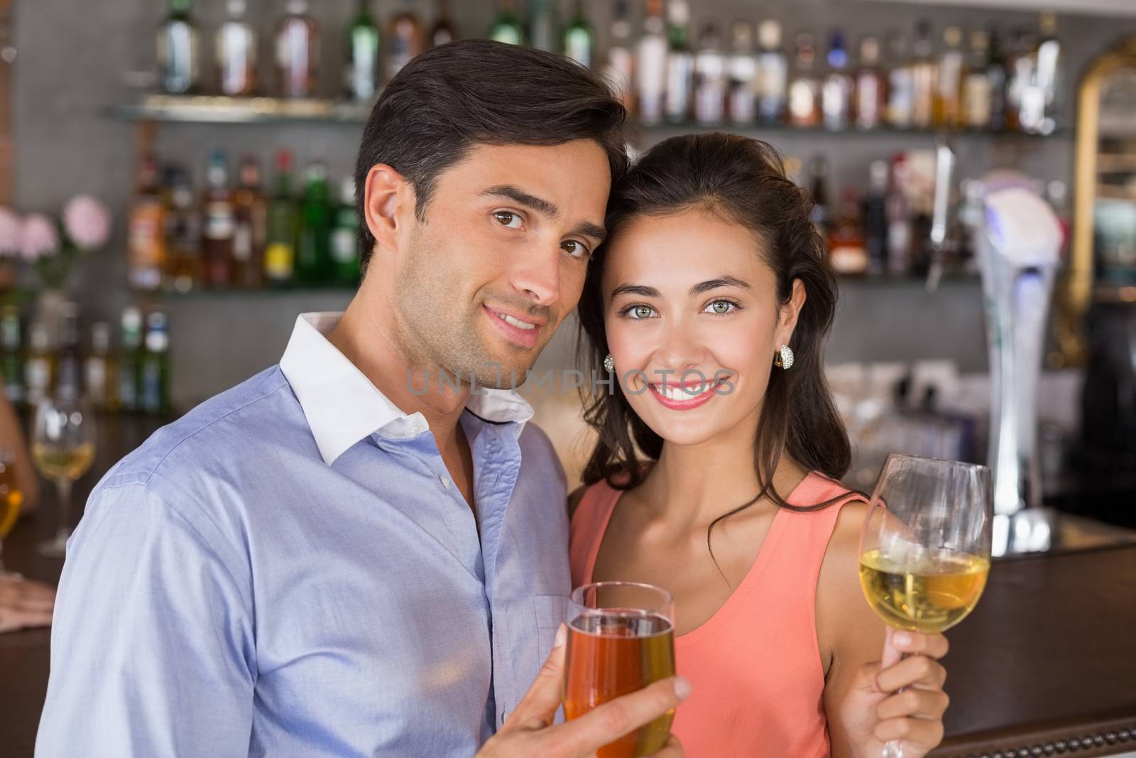 Portrait of romantic couple holding wine glasses in restaurant