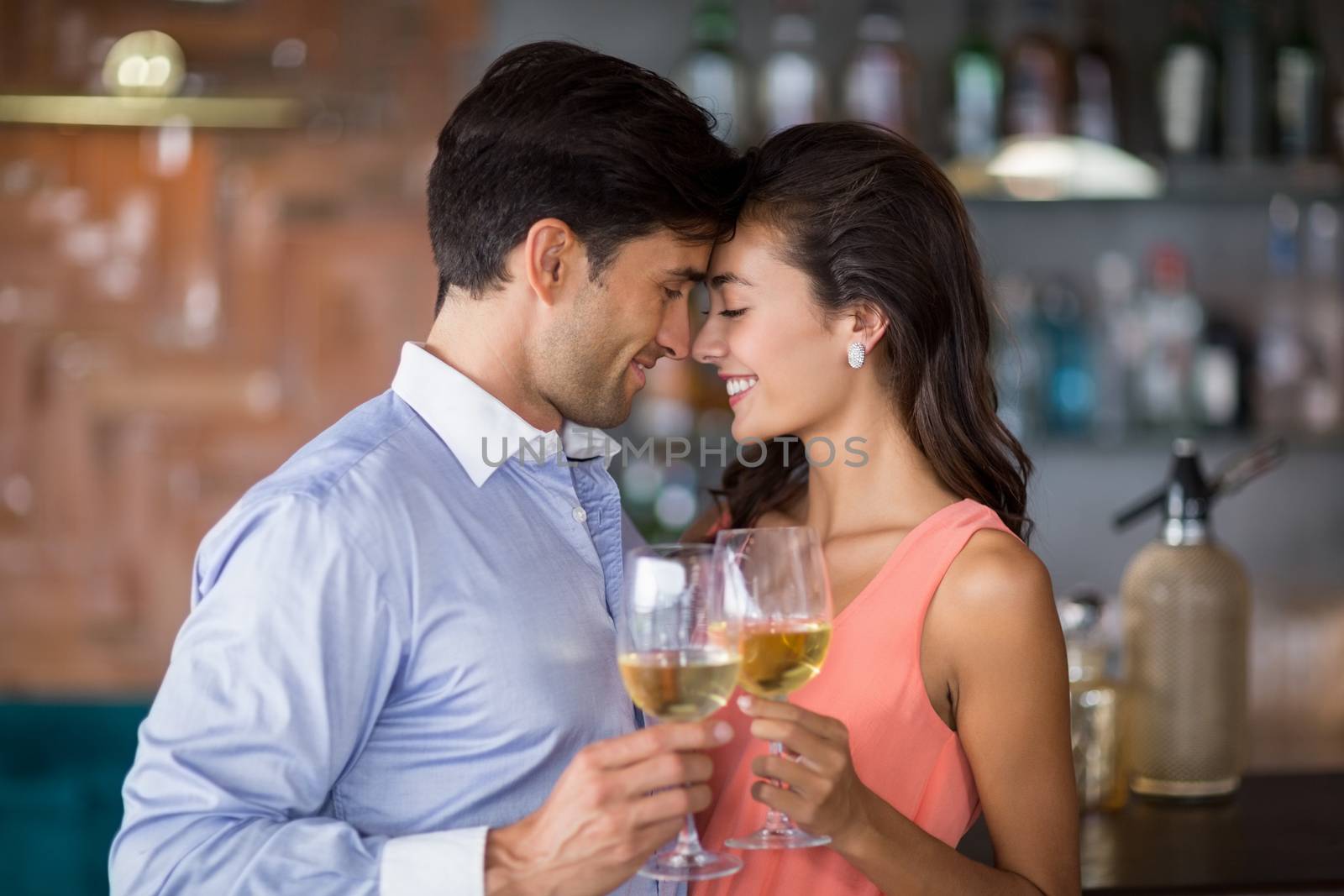 Romantic young couple toasting wine glasses in restaurant