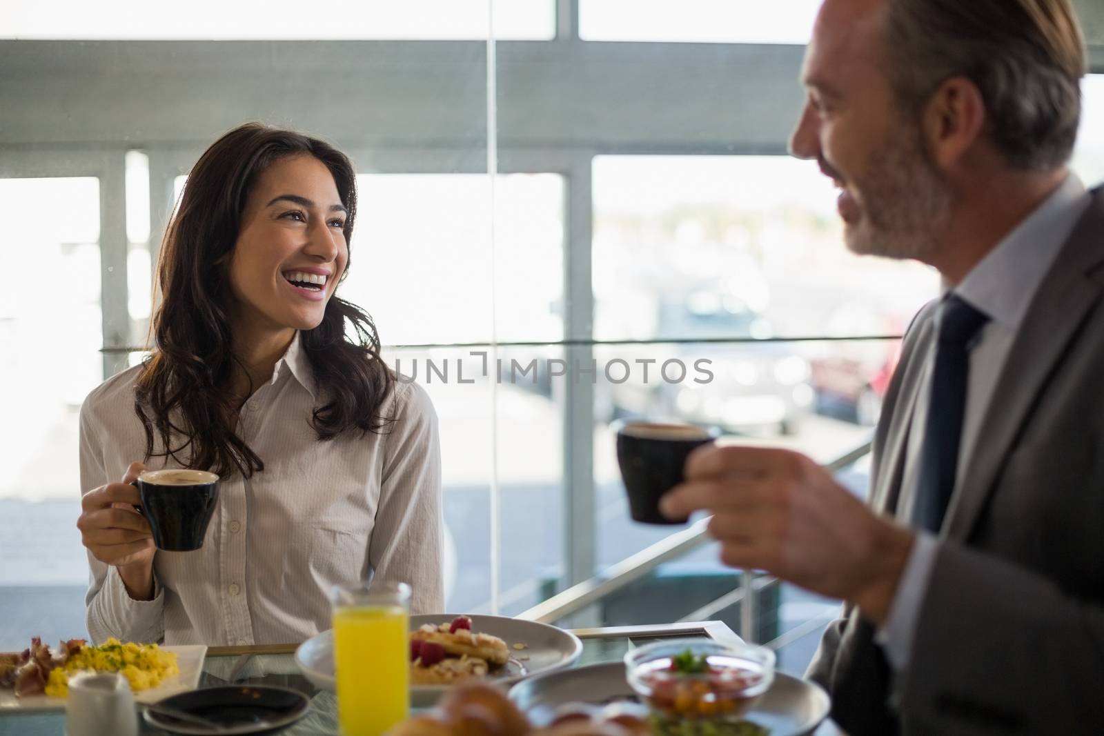 Business people interacting with eachother while having meal in restaurant