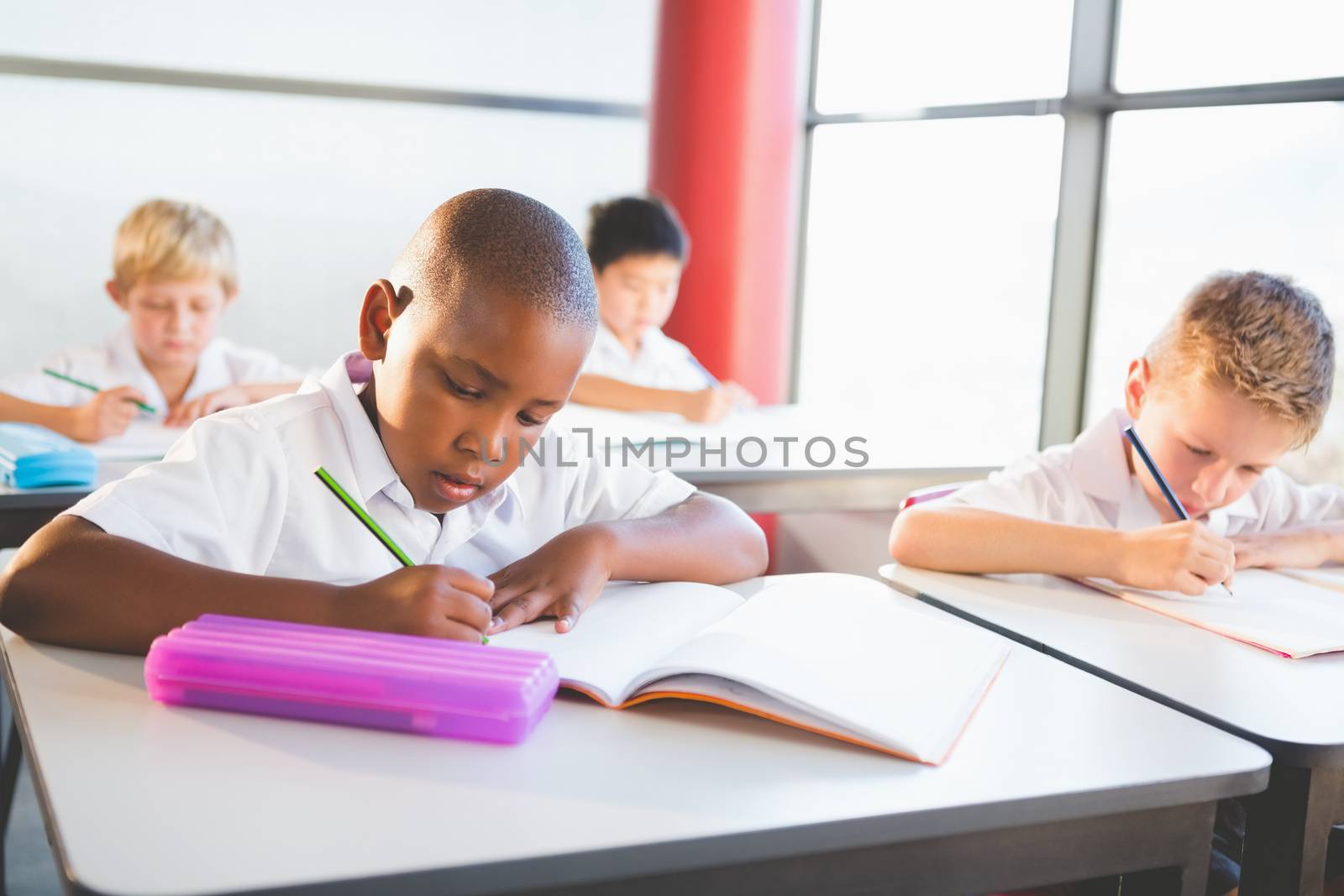 School kids doing homework in classroom by Wavebreakmedia