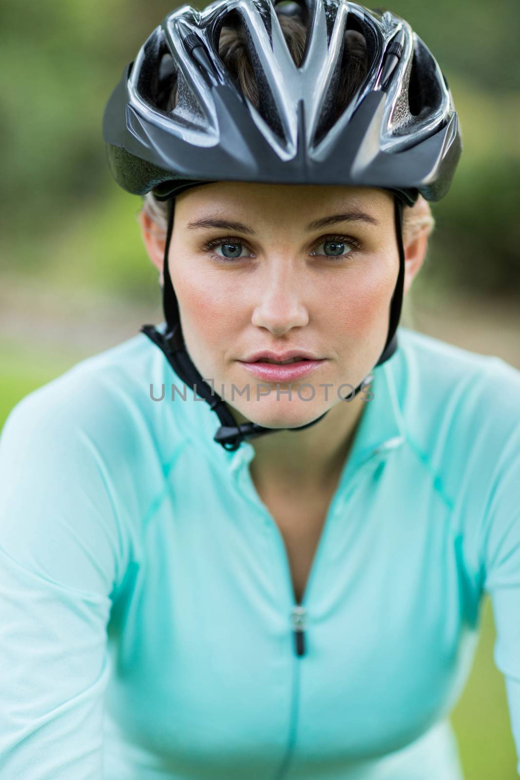 Portrait of female cyclist wearing bicycle helmet outdoors