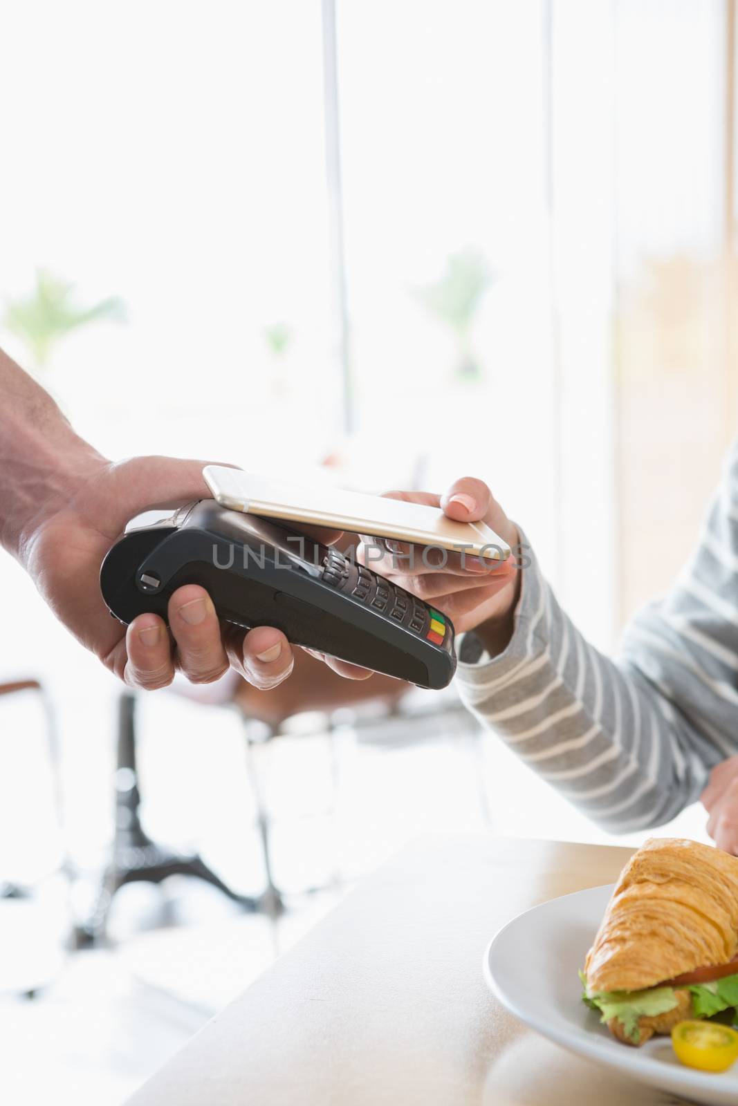 Woman making payment through NFC in cafeteria