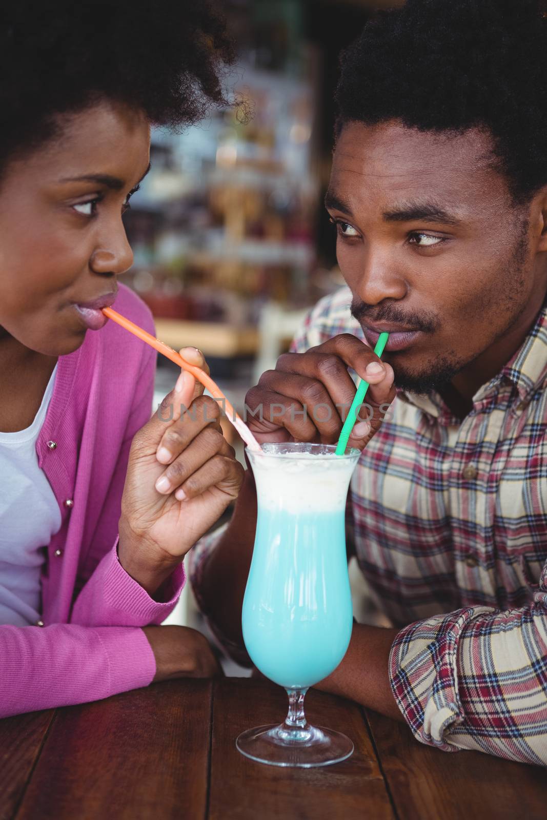 Close-up of young couple having mocktail in cafeteria