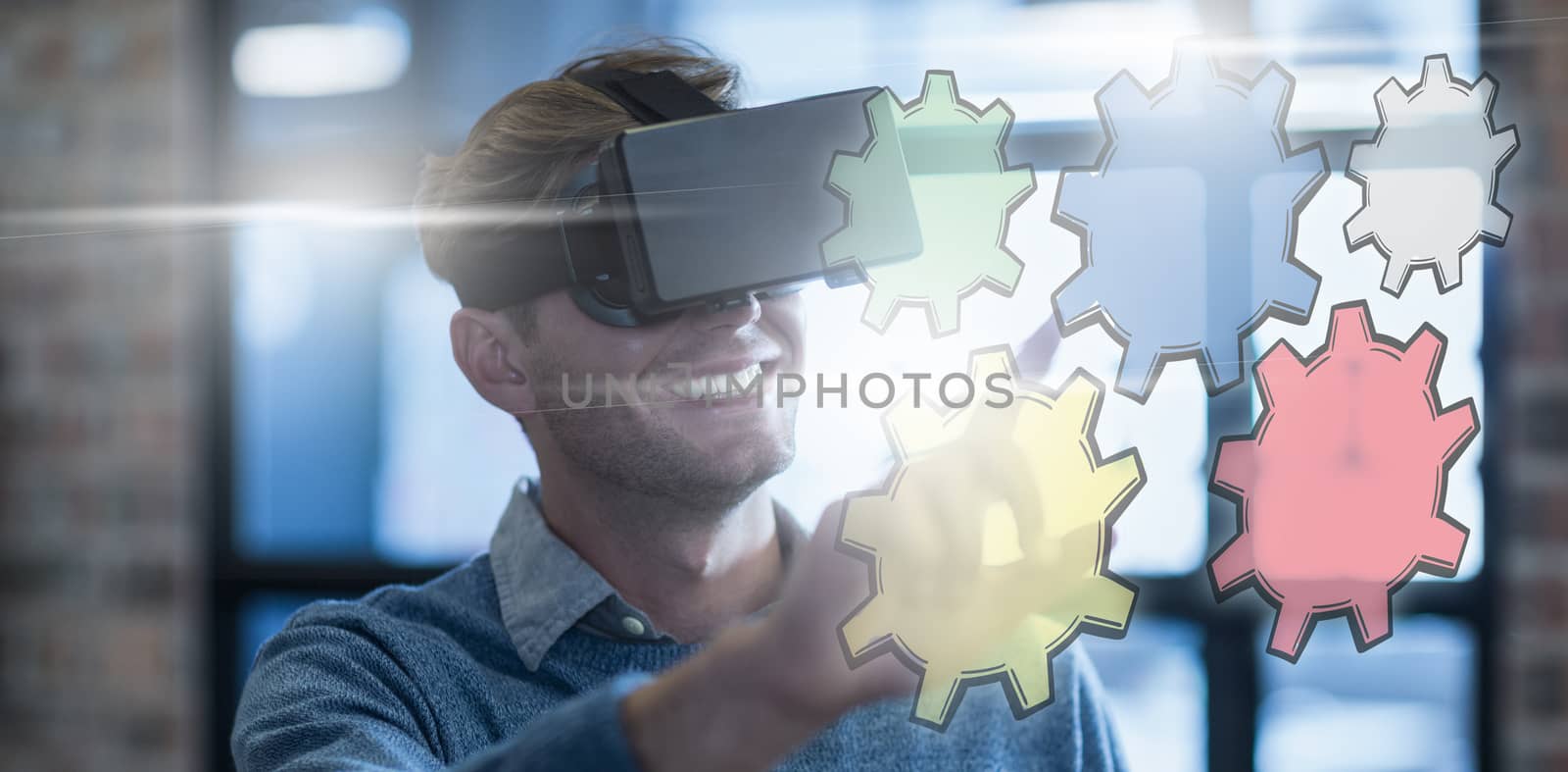 Colured cogs against businessman using virtual reality headset in office
