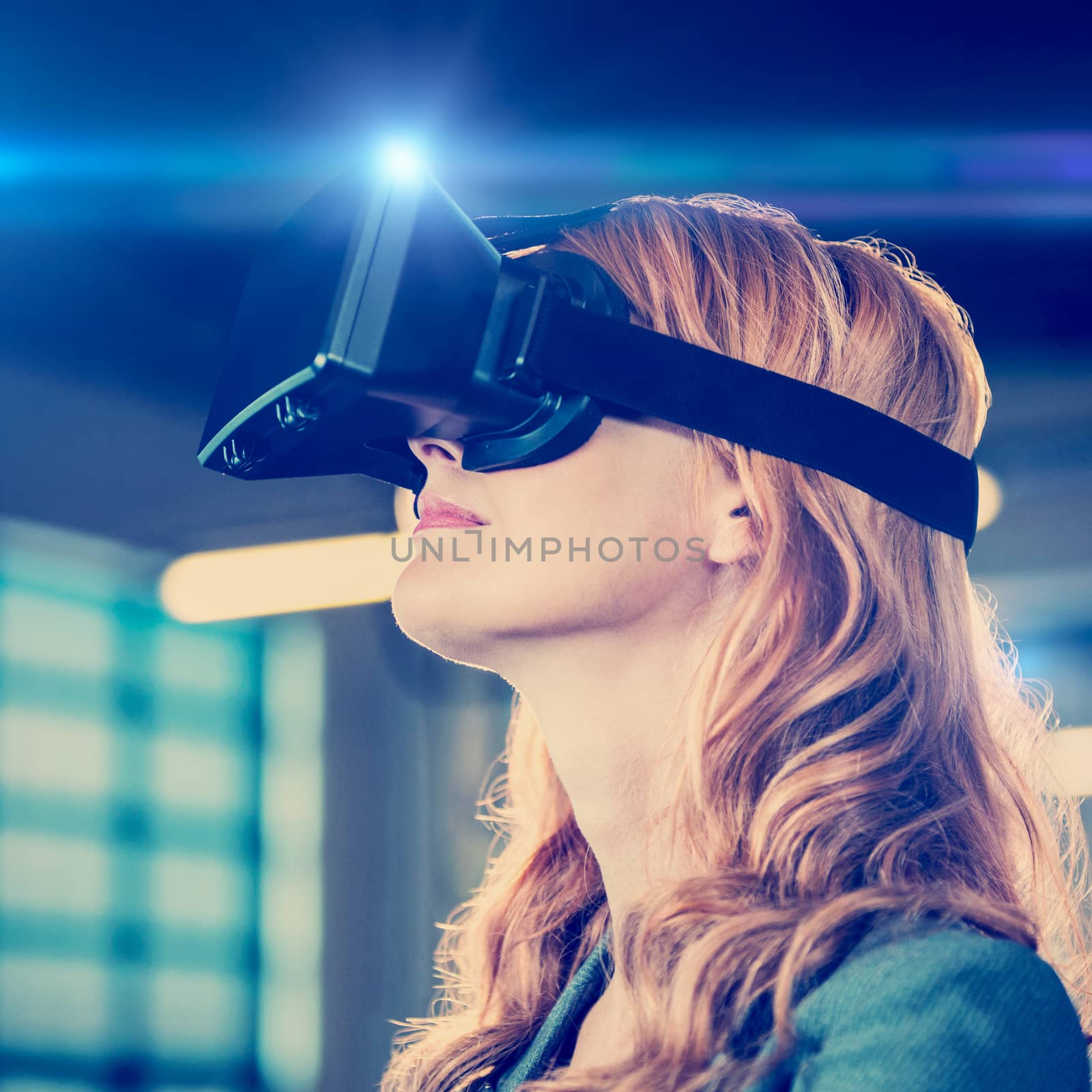Side view of young businesswoman using virtual reality simulator in office