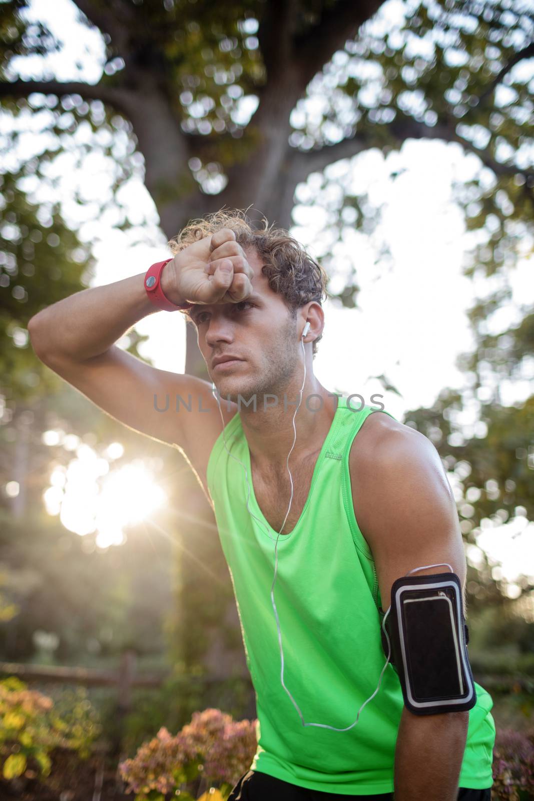 Tired man taking a break while jogging in park