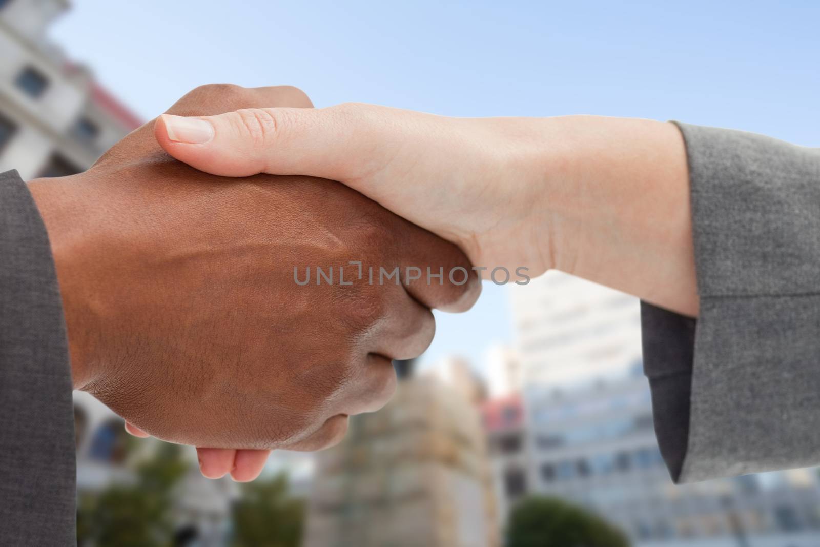Business people giving a handshake in front of city