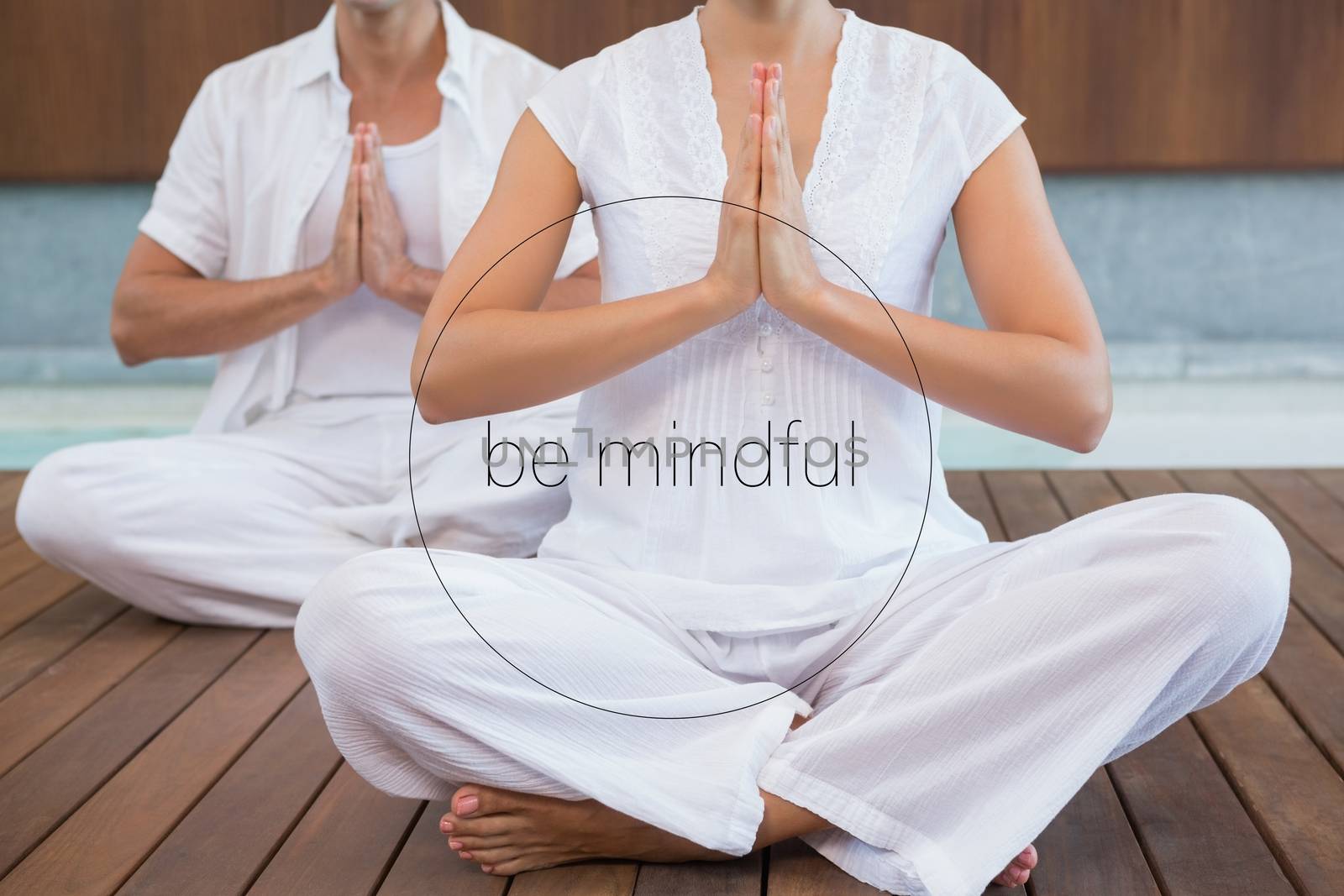 Couple performing yoga on a wooden floor