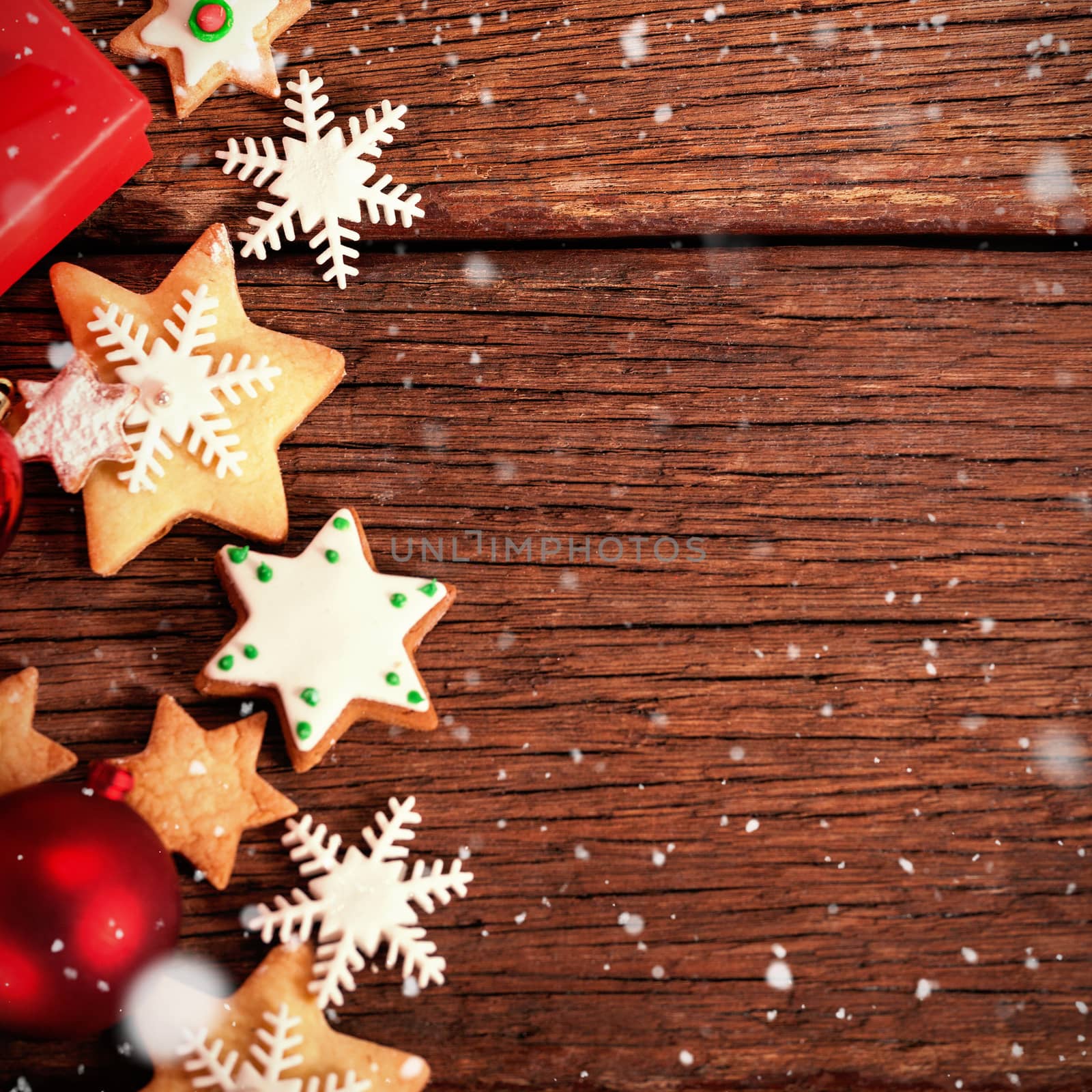 Snow falling against cookies with christmas decorations
