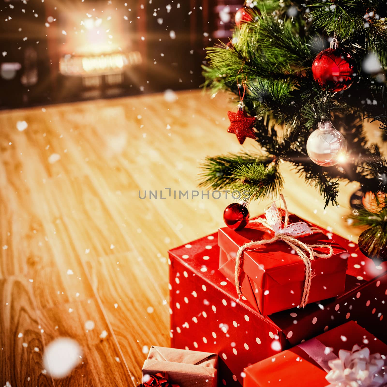 Snow falling against wrapped gifts near a christmas tree