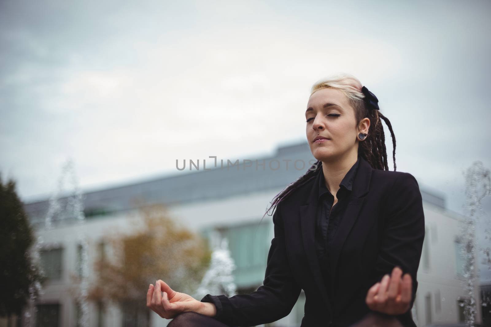 Businesswoman practicing yoga in office campus