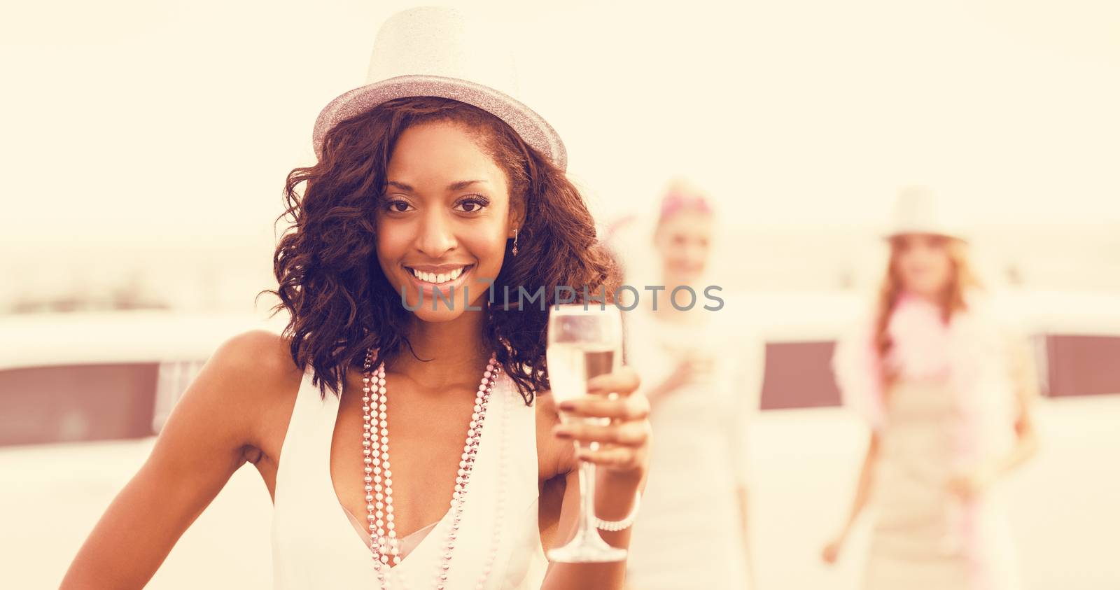 Portrait of friends holding champagne glasses while standing at outdoors