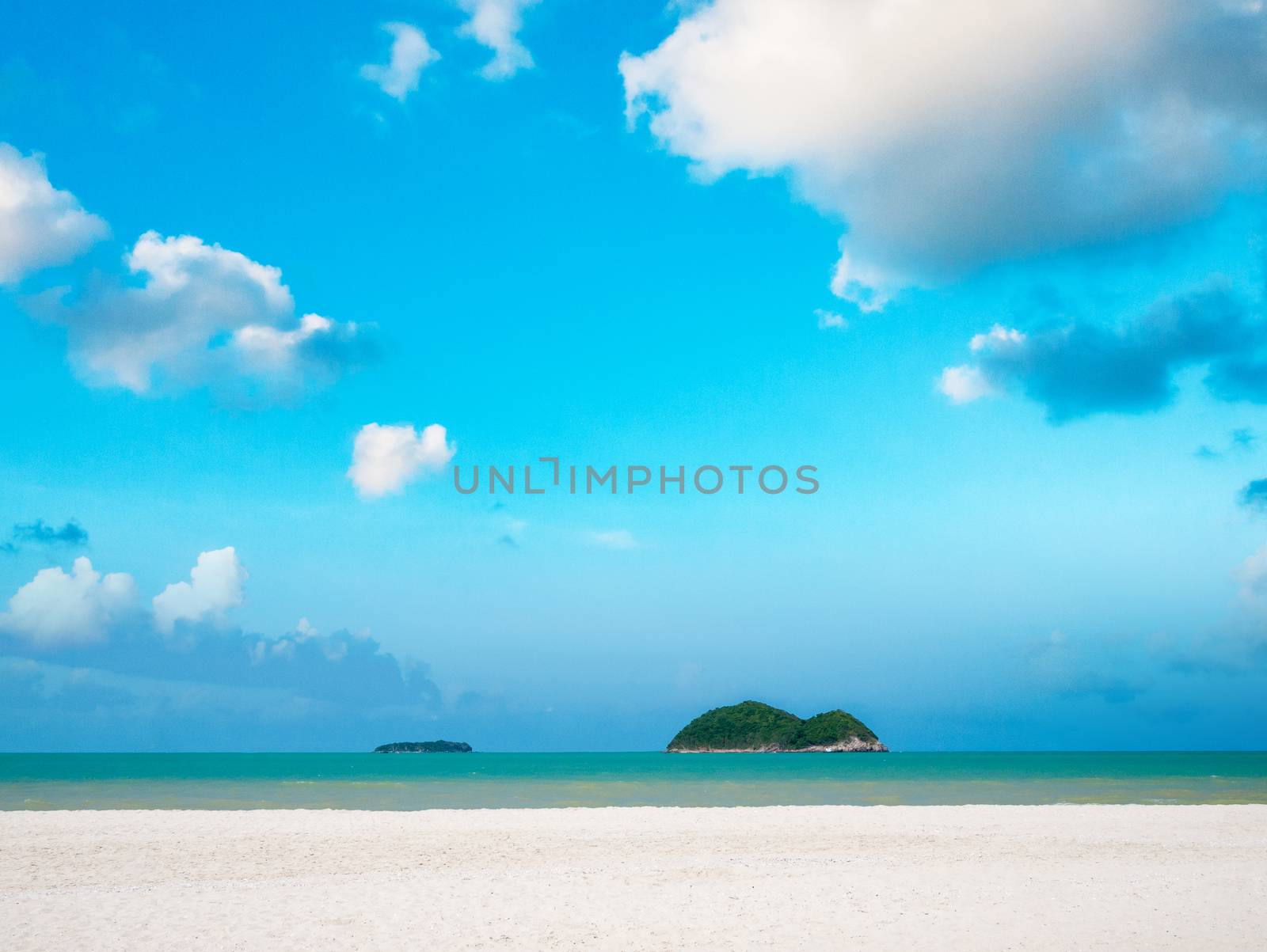 White sand beach with bright blue sky and cloud over sea with two island 