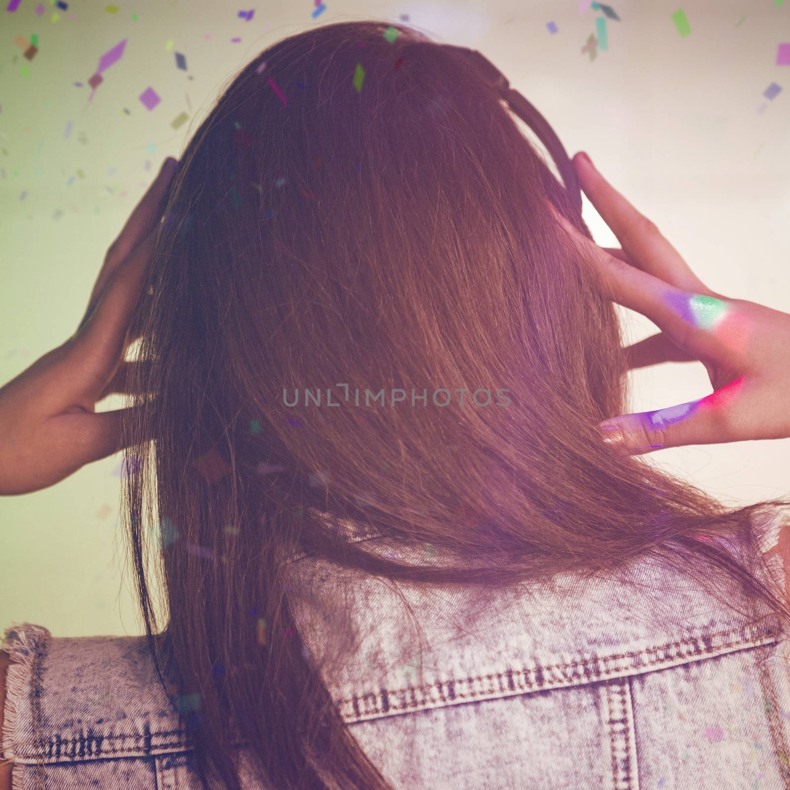 Rear view of DJ listening music on headphone against flying colours
