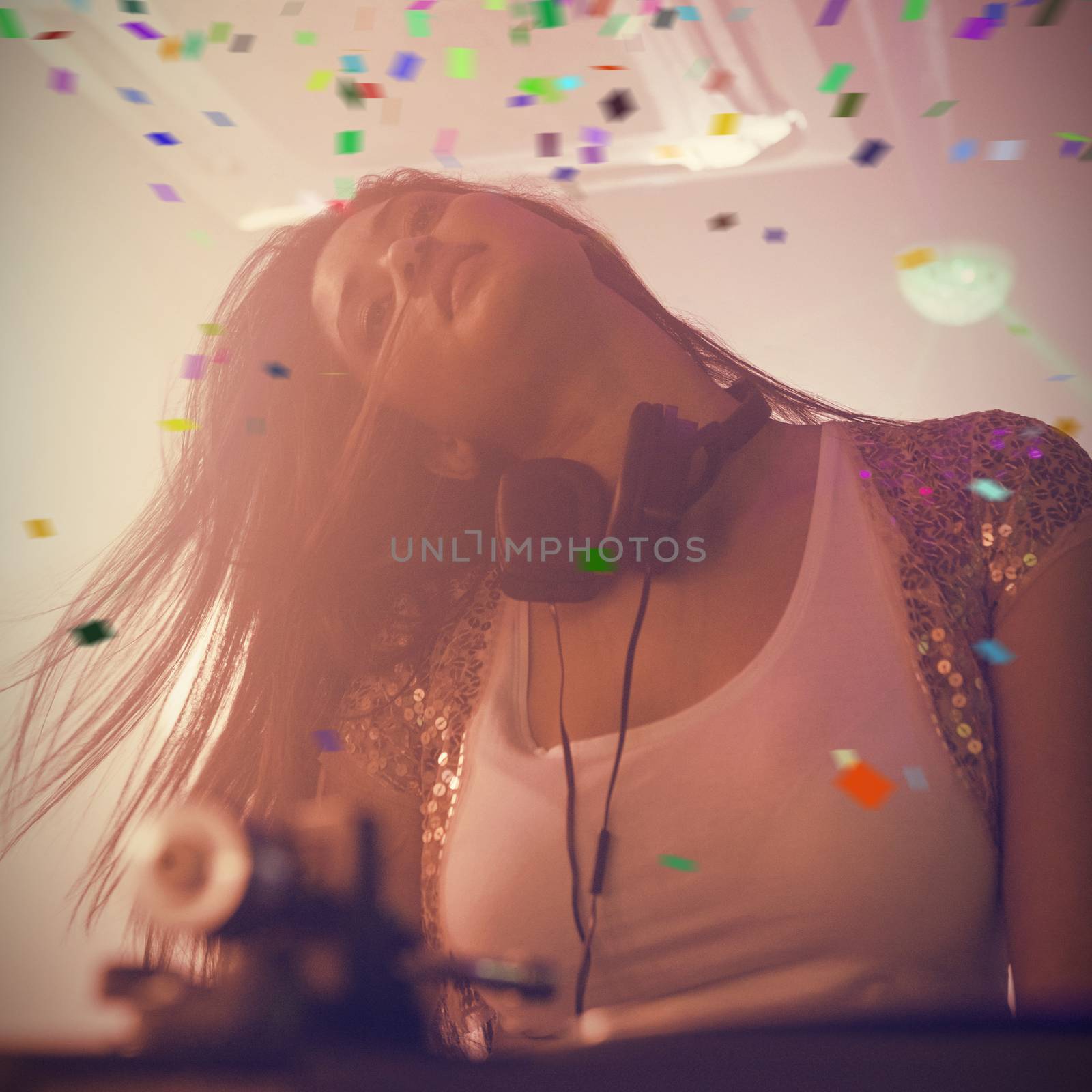 Pretty female DJ dancing against flying colours