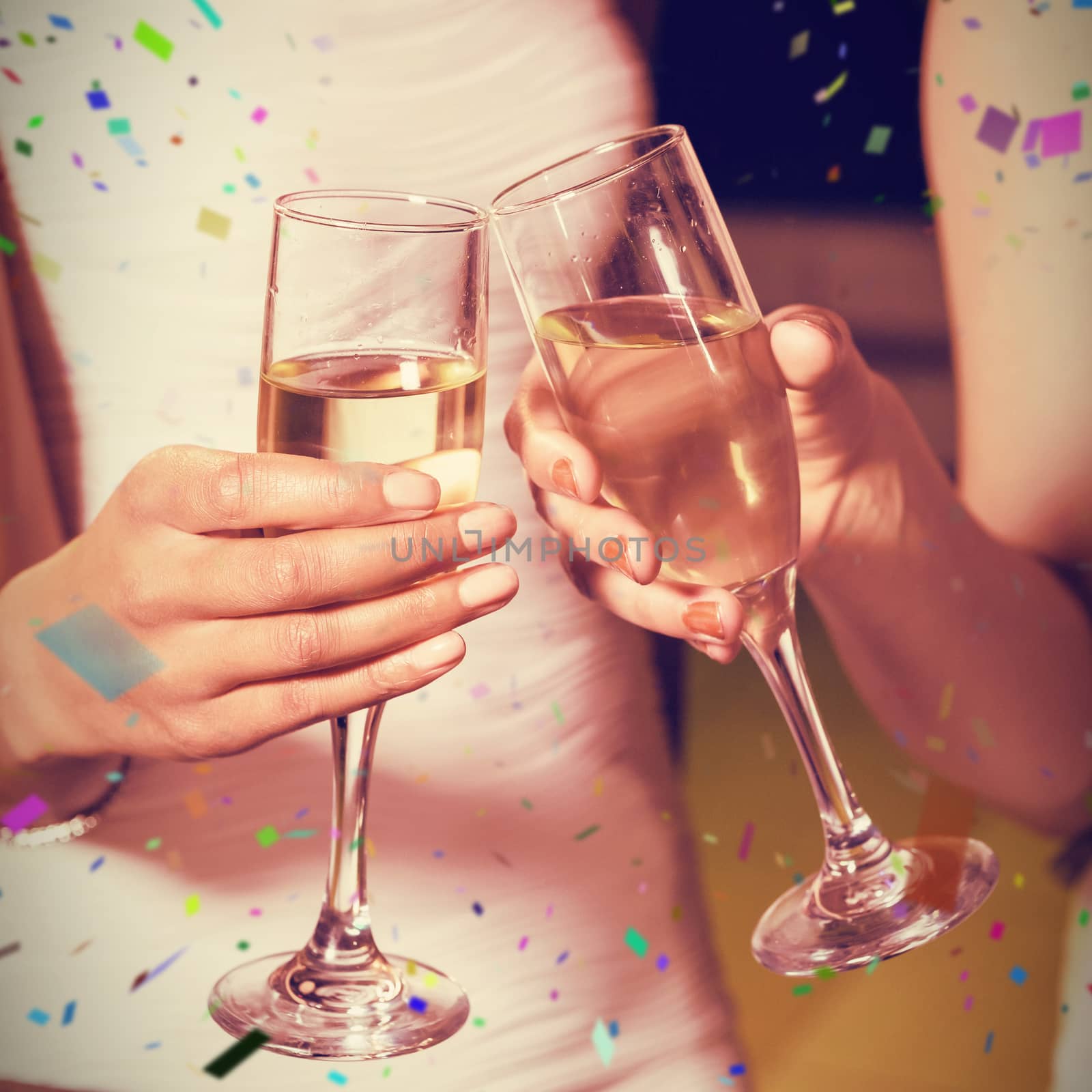 Young women toasting champagne flute against flying colours