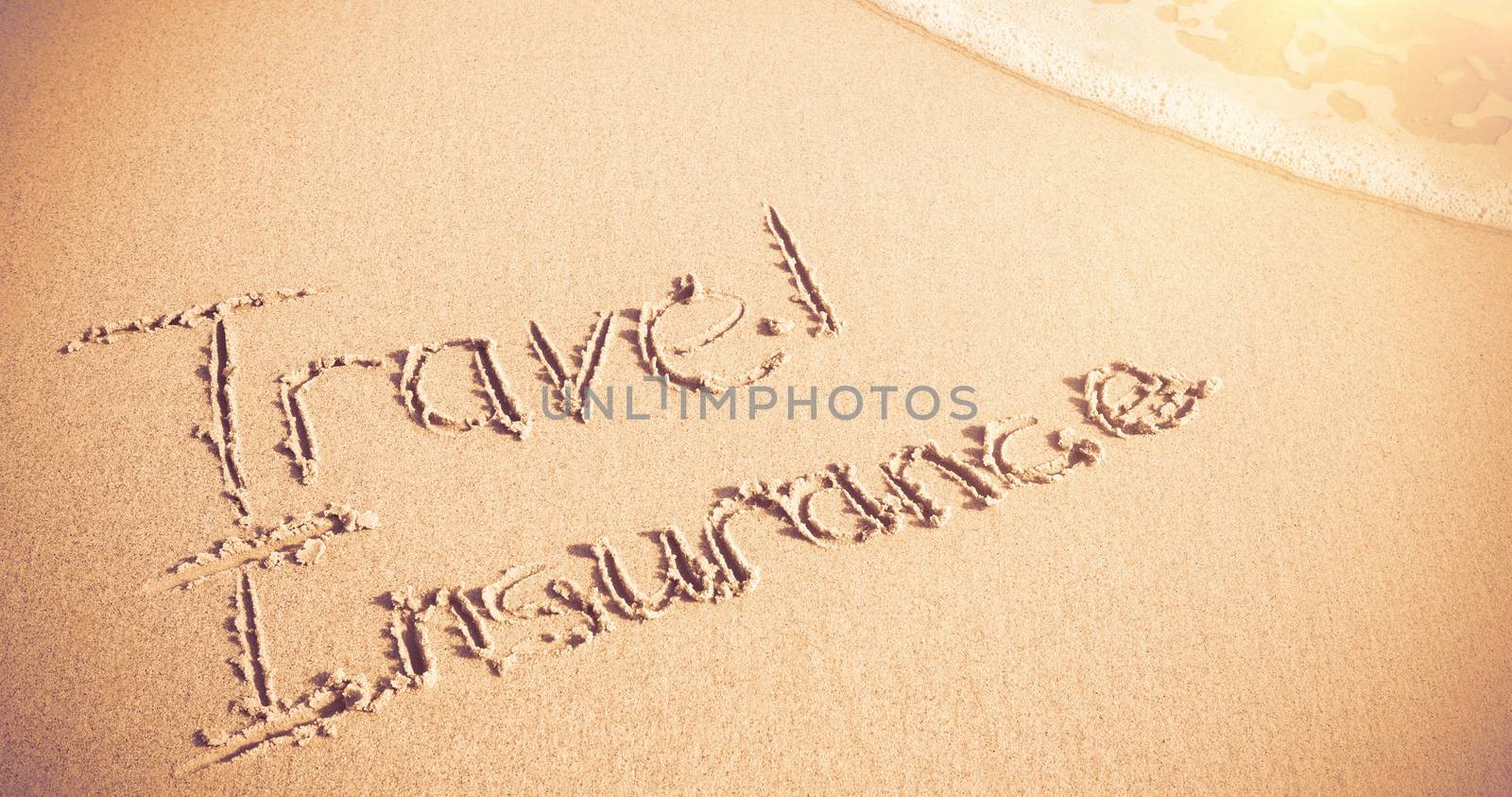 Travel Insurance written on sand by Wavebreakmedia