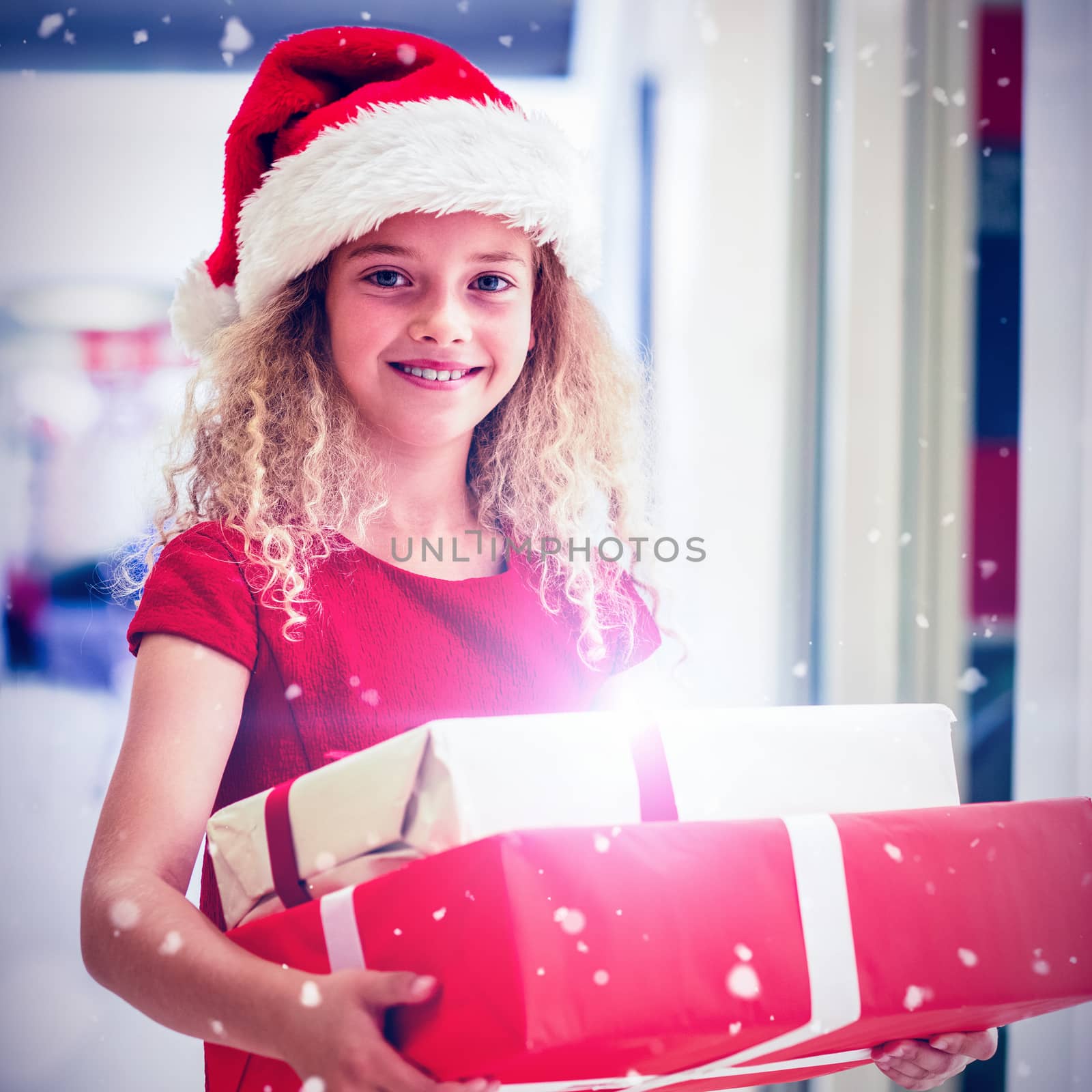 Portrait of girl in Christmas attire standing with gifts against snow falling