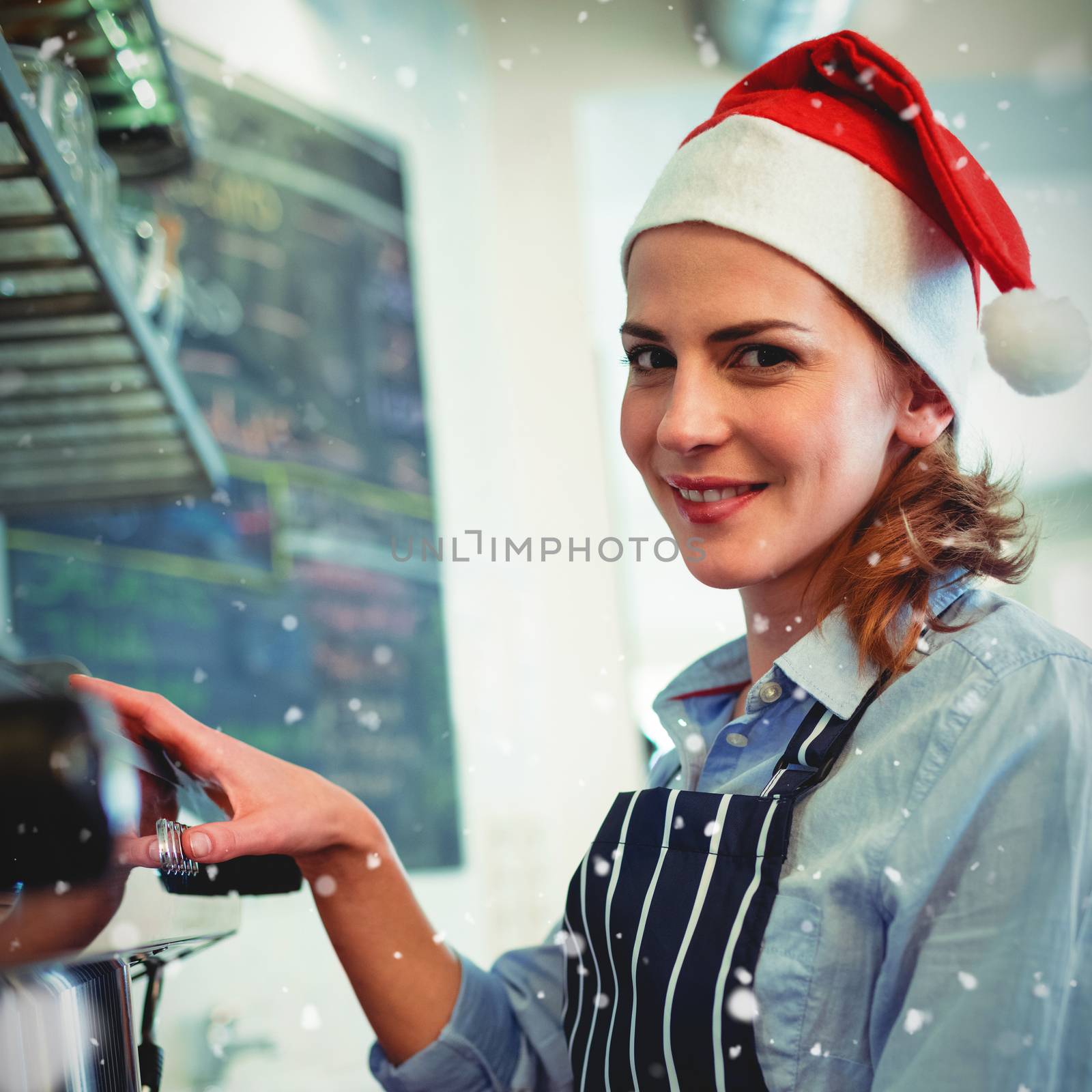 Portrait of waitress using coffee maker at cafeteria during Christmas against snow falling