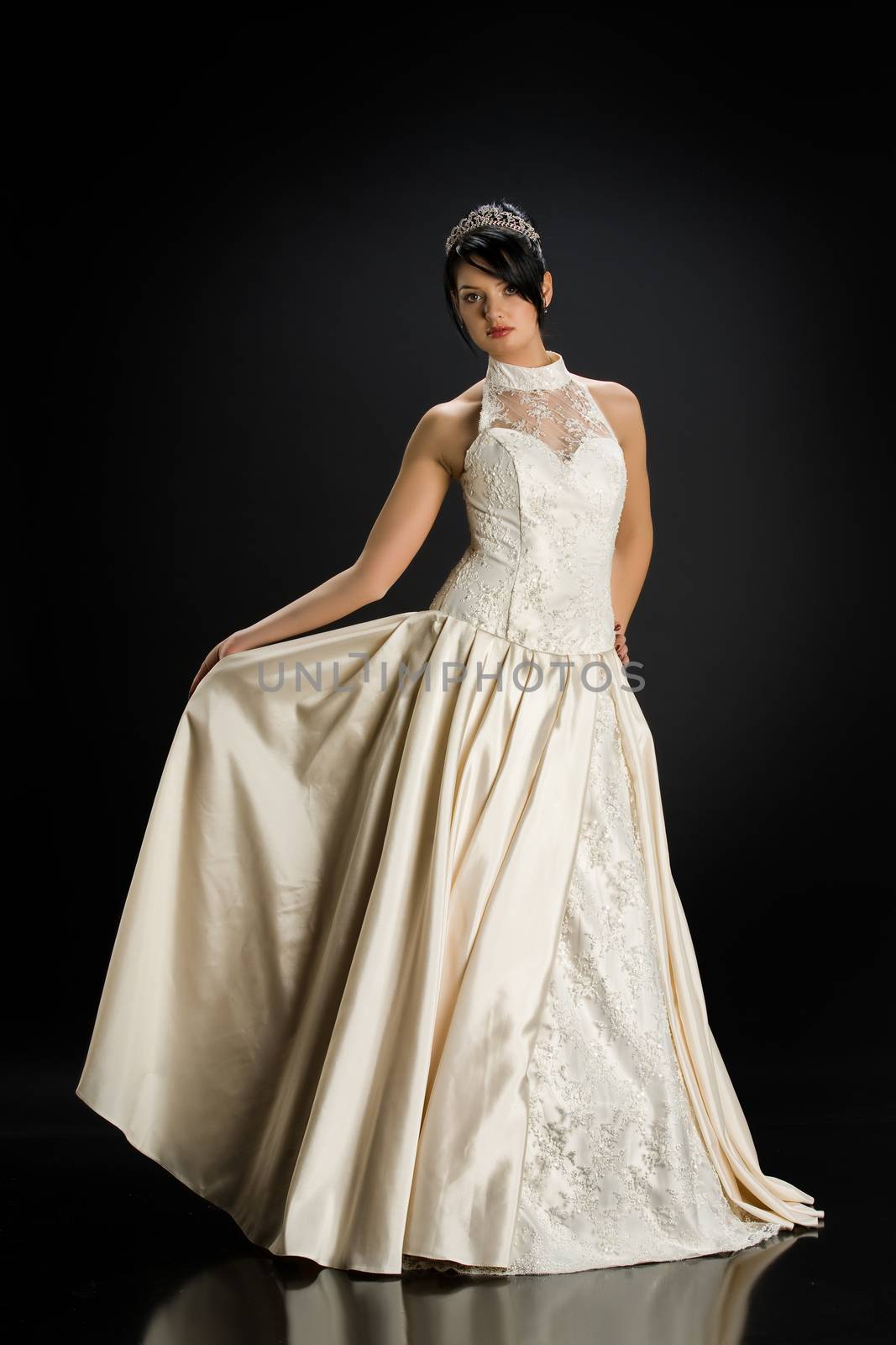 Young beautiful woman in a wedding dress on a studio background