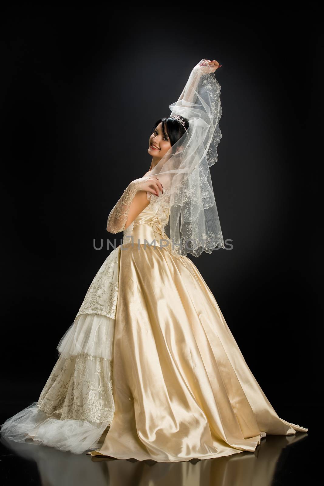 Young beautiful woman in a wedding dress on a studio background