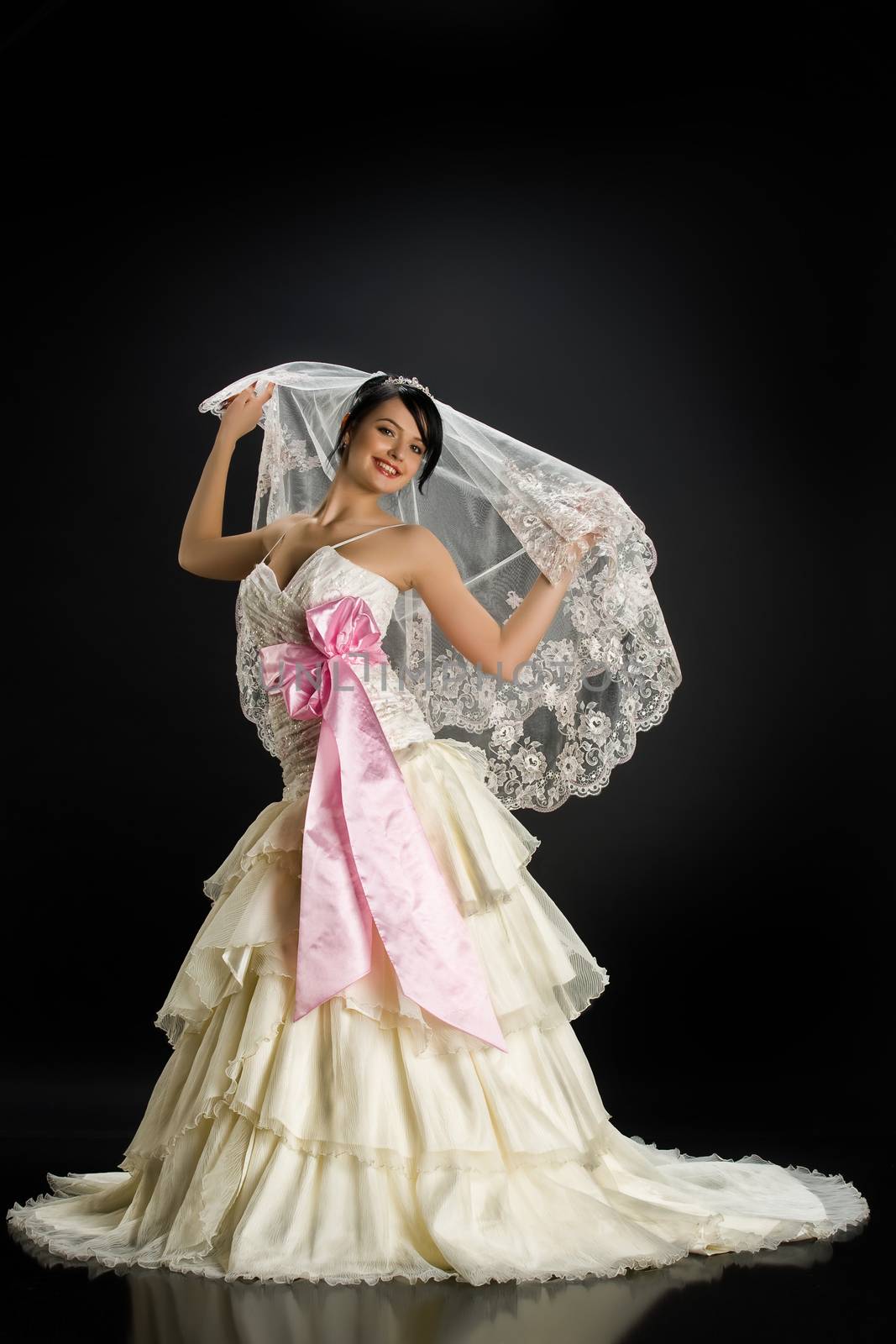 Young beautiful woman in a wedding dress on a studio background