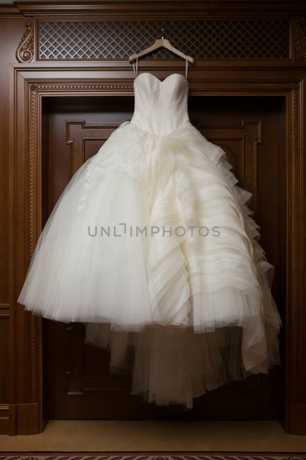 Wedding dress is hanging on the closet. Stylish photo.