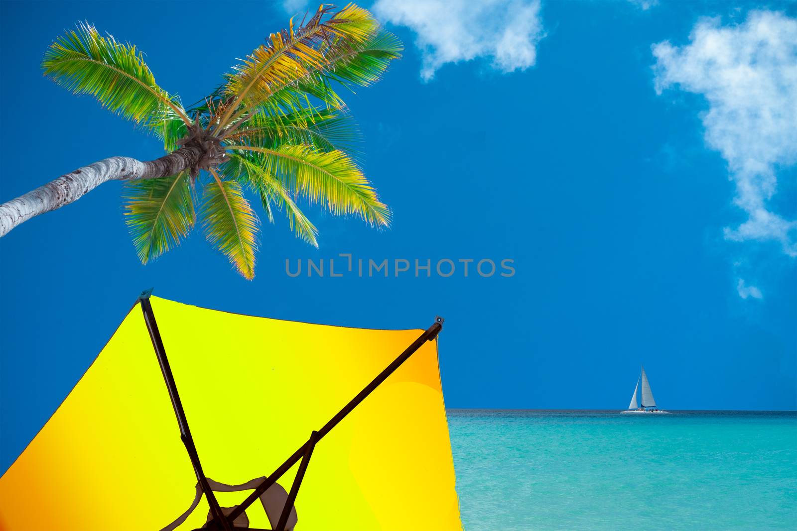 An umbrella under a palm tree and a sailboat on the horizon, a collage on the theme of relaxation by the sea

