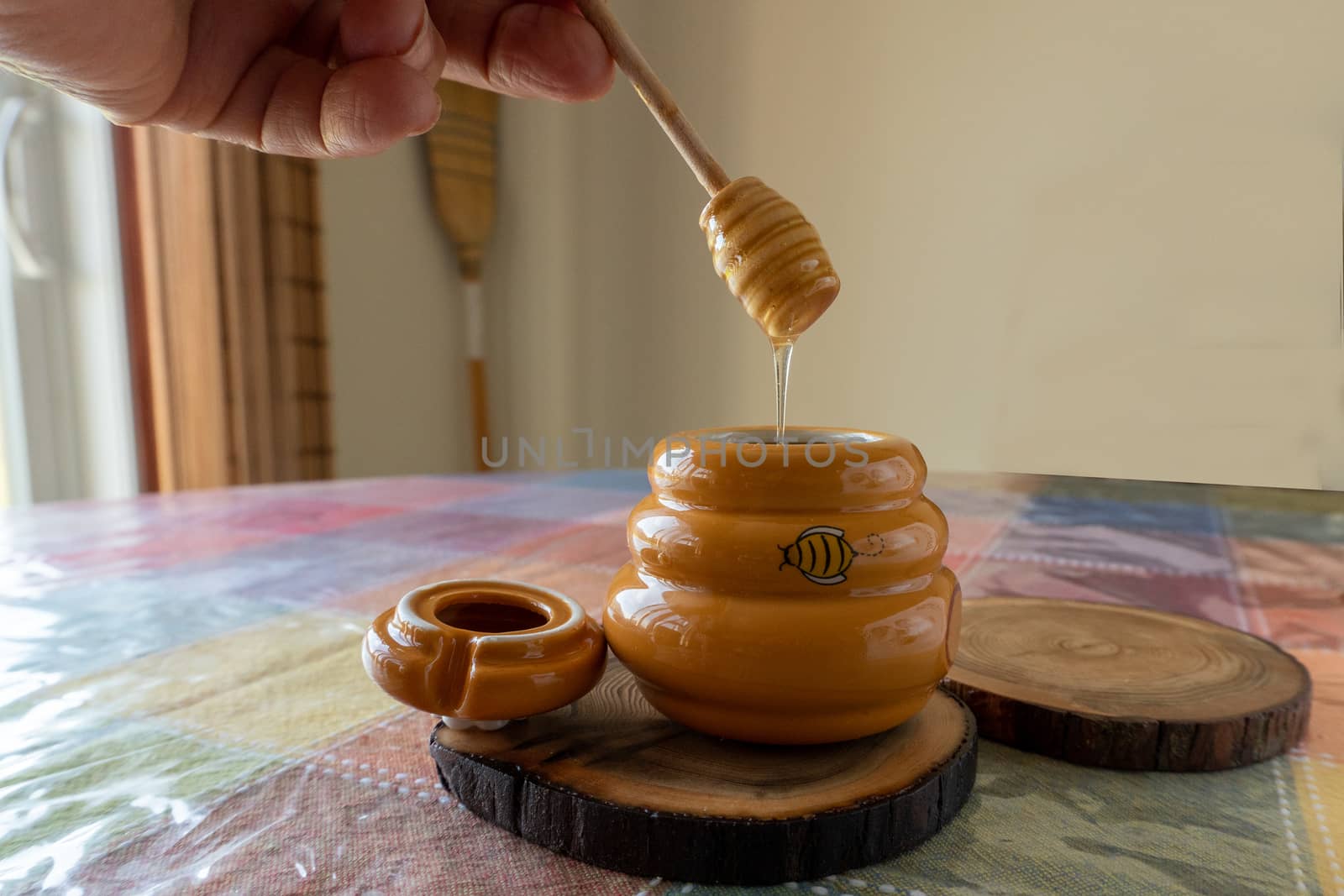 Ceramic yellow jar with linden honey stands on the table
