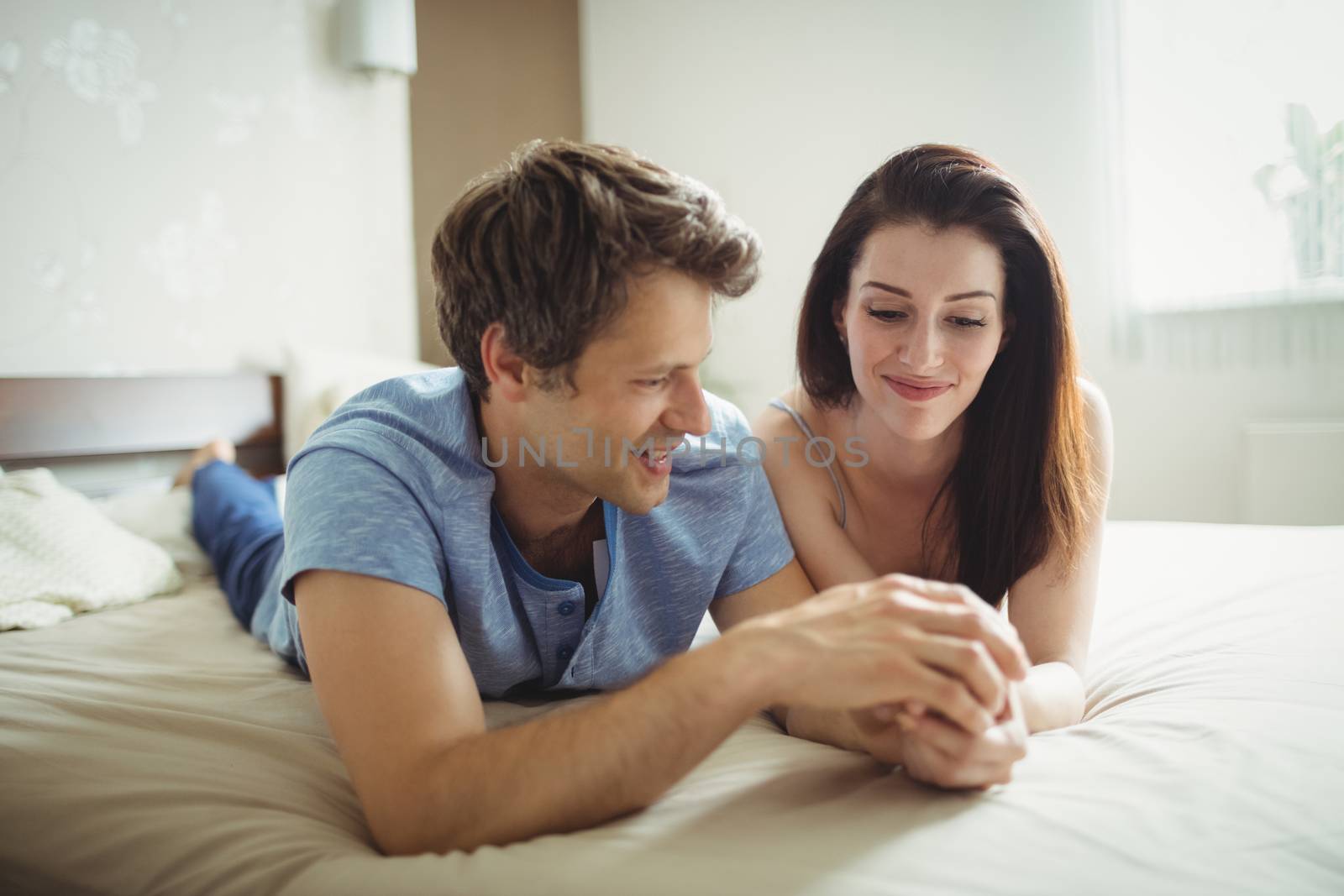 Romantic couple relaxing on bed in bedroom