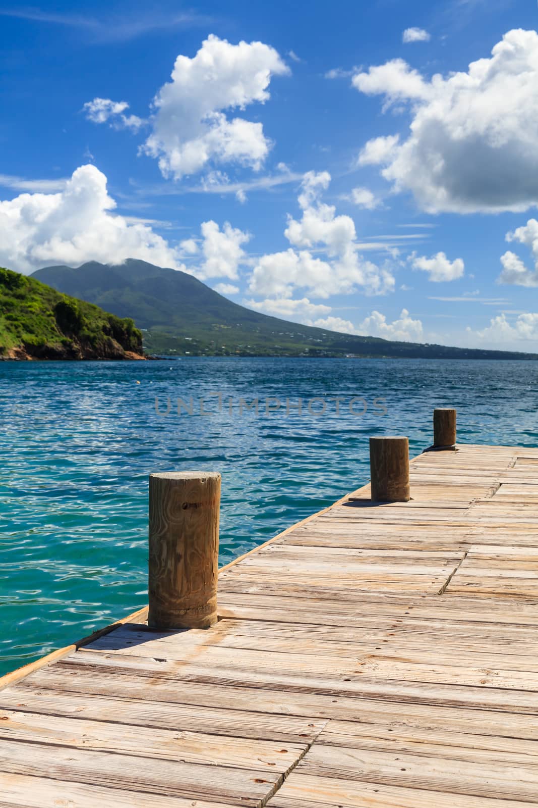 The pier is located on Cockleshell Bay on the Caribbean island of St. Kitts in the West Indies.  The island of Nevis can be seen in the background.
