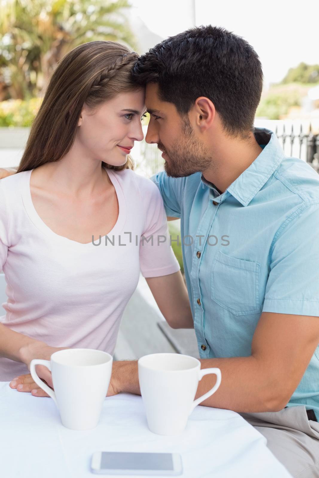 Romantic young couple looking at each other at the coffee shop