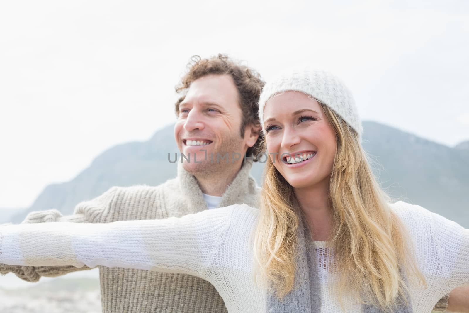 Casual young couple stretching hands out outdoors by Wavebreakmedia