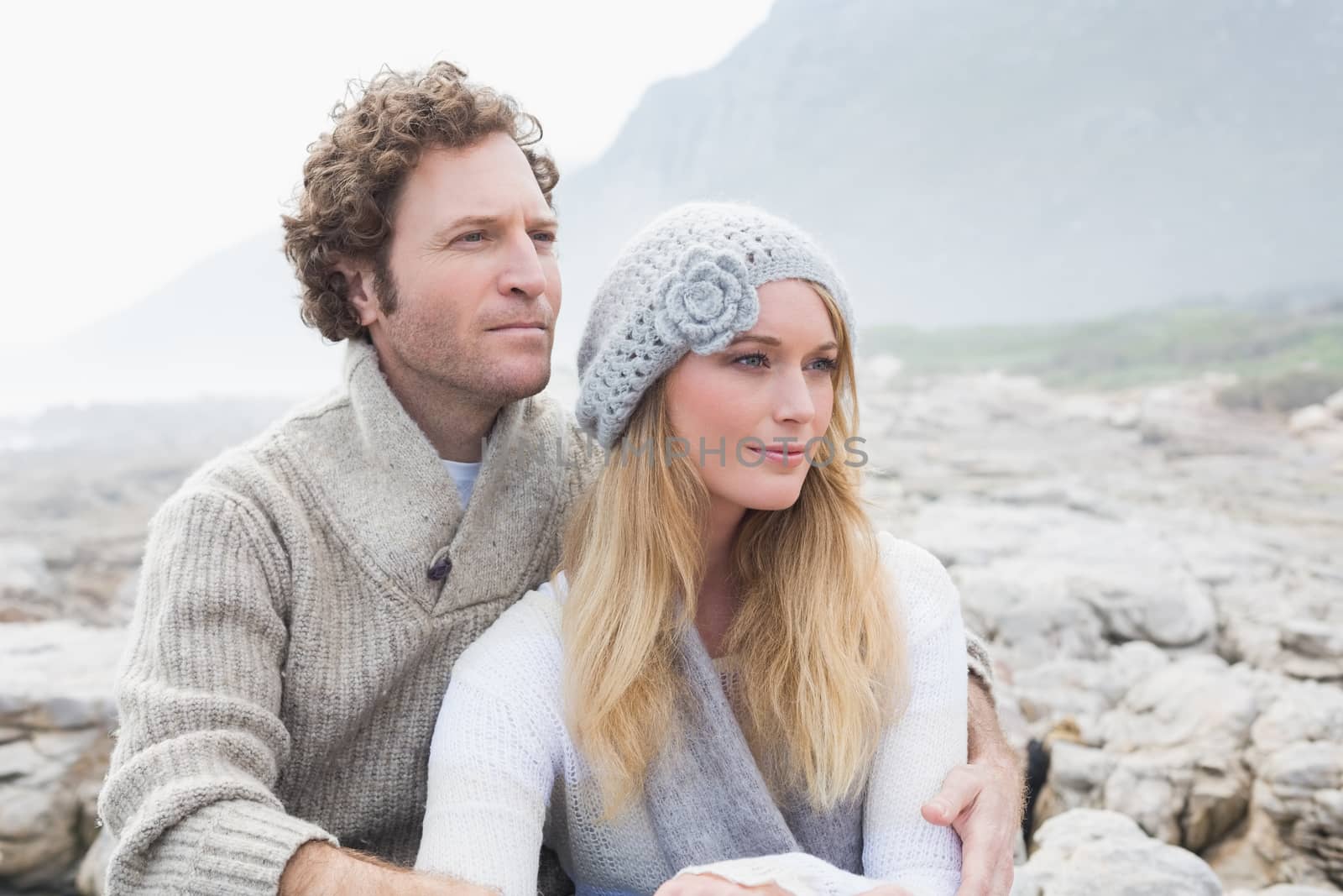 Romantic young couple sitting together on a rocky landscape