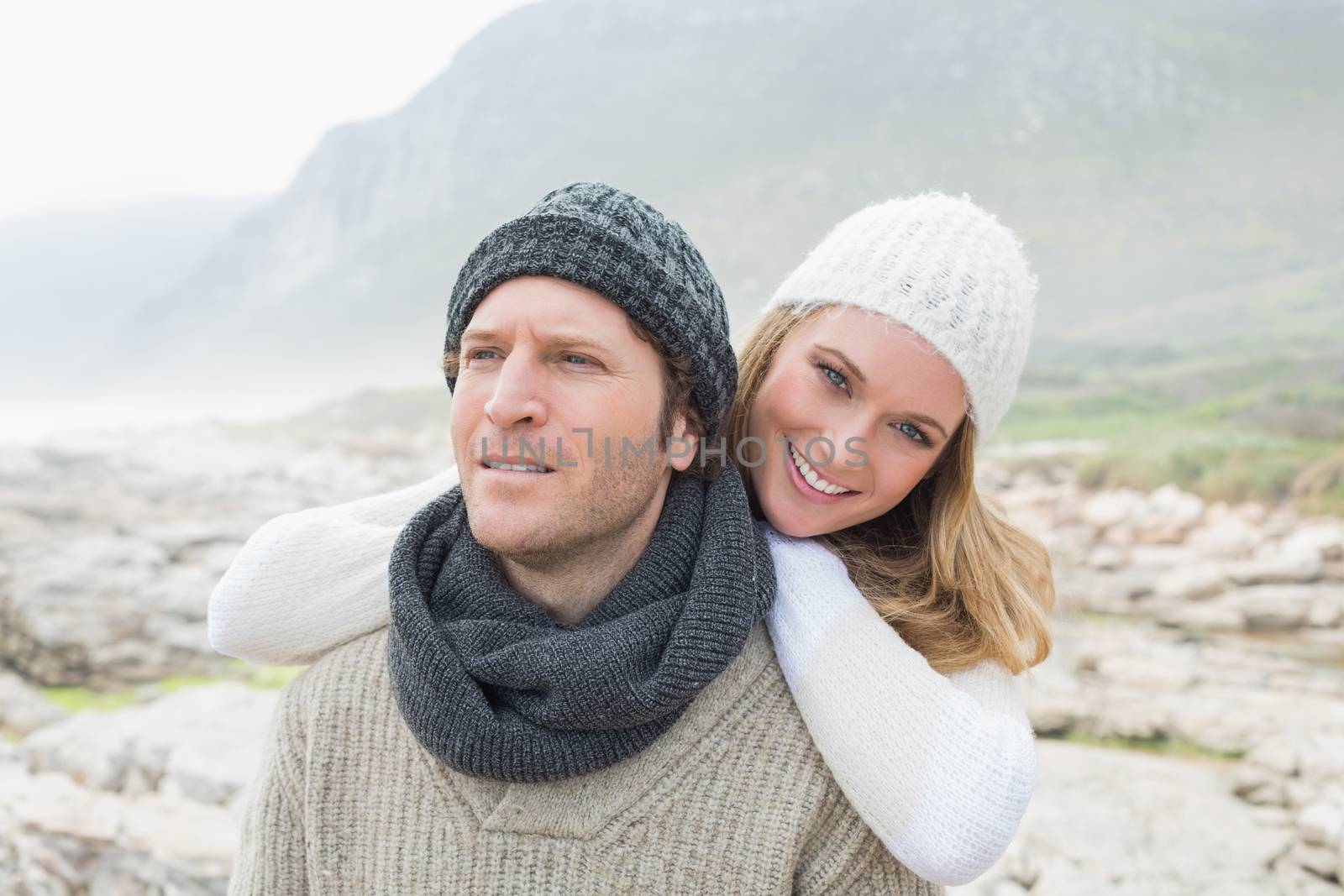 Portrait of a happy romantic young couple standing together on a rocky landscape