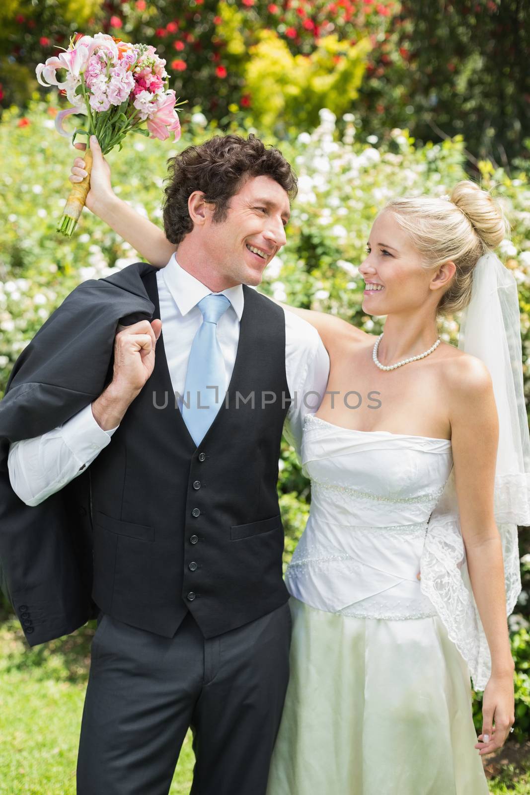 Romantic newlywed couple smiling at each other in the countryside