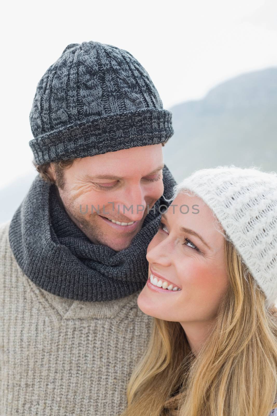 Closeup of a romantic young couple in warm clothing outdoors