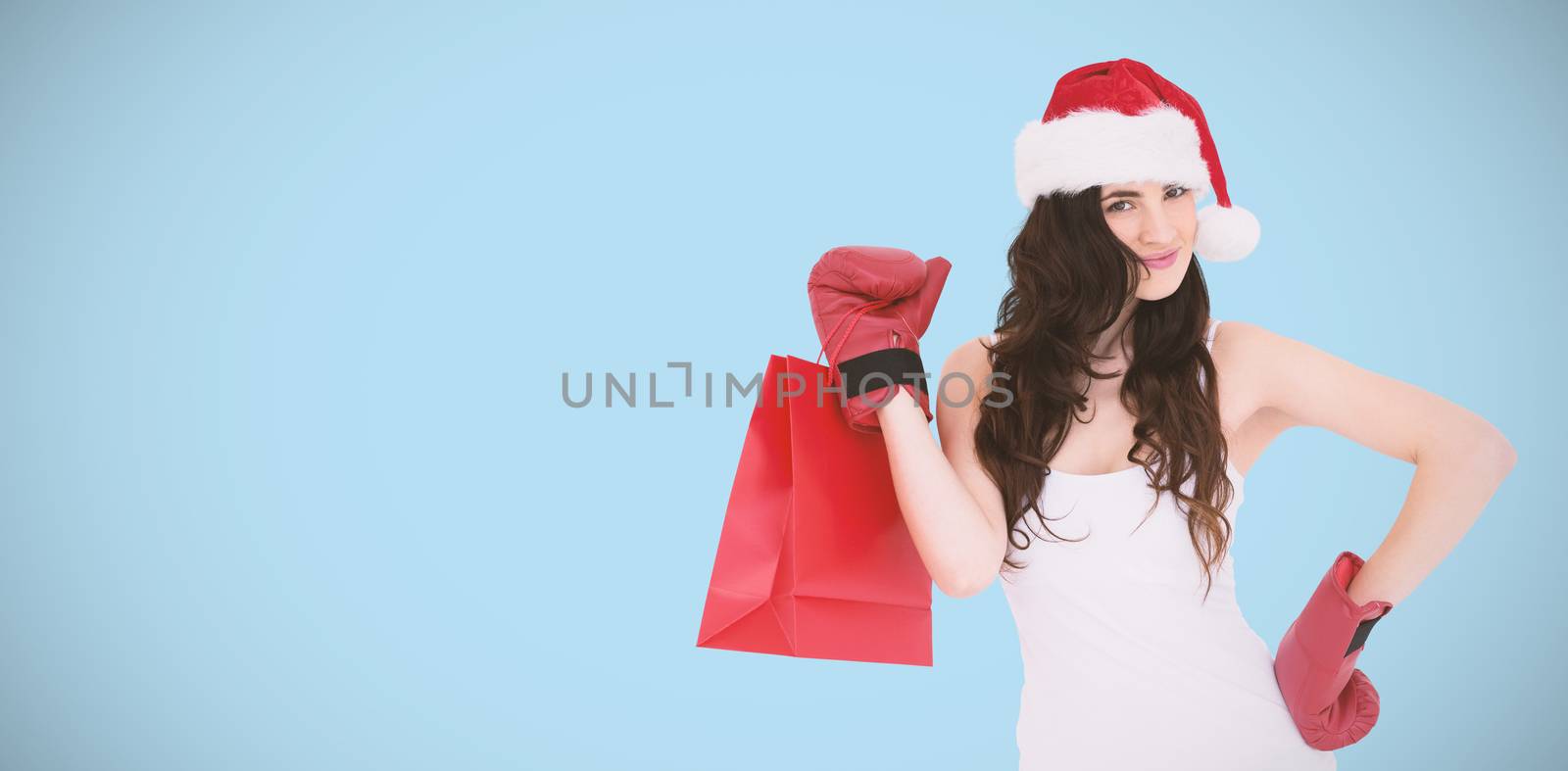 Beauty brunette in boxing gloves with shopping bag against blue background