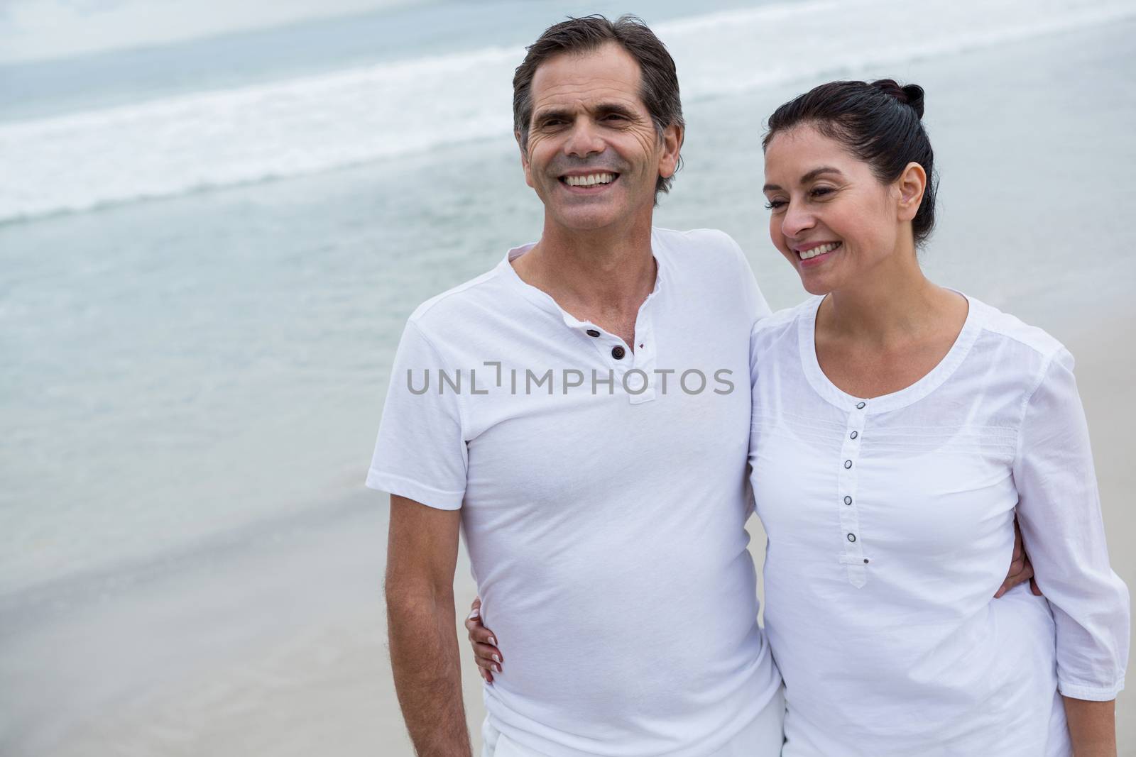 Romantic couple standing on beach during winter