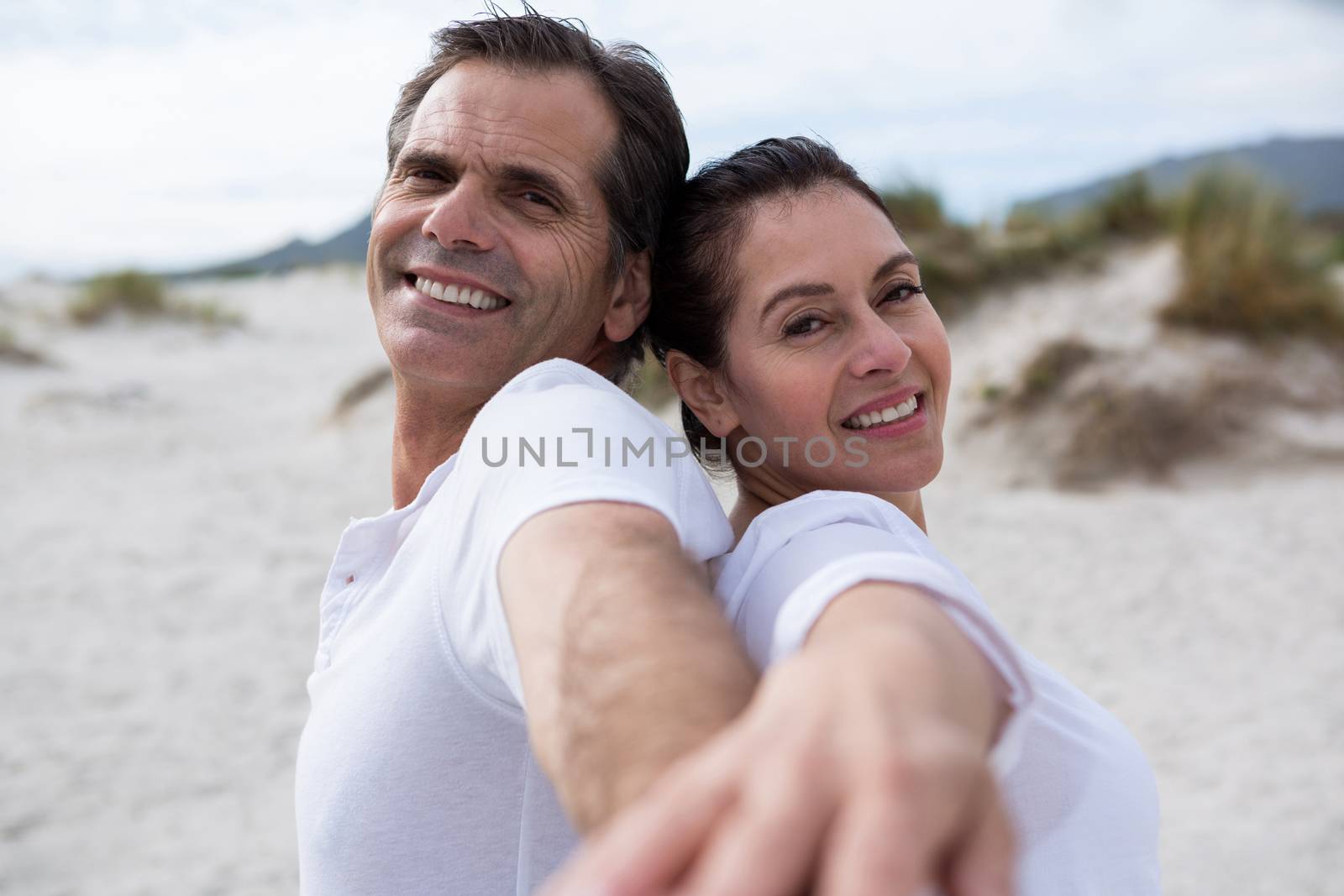 Portrait of romantic couple enjoying on beach during winter